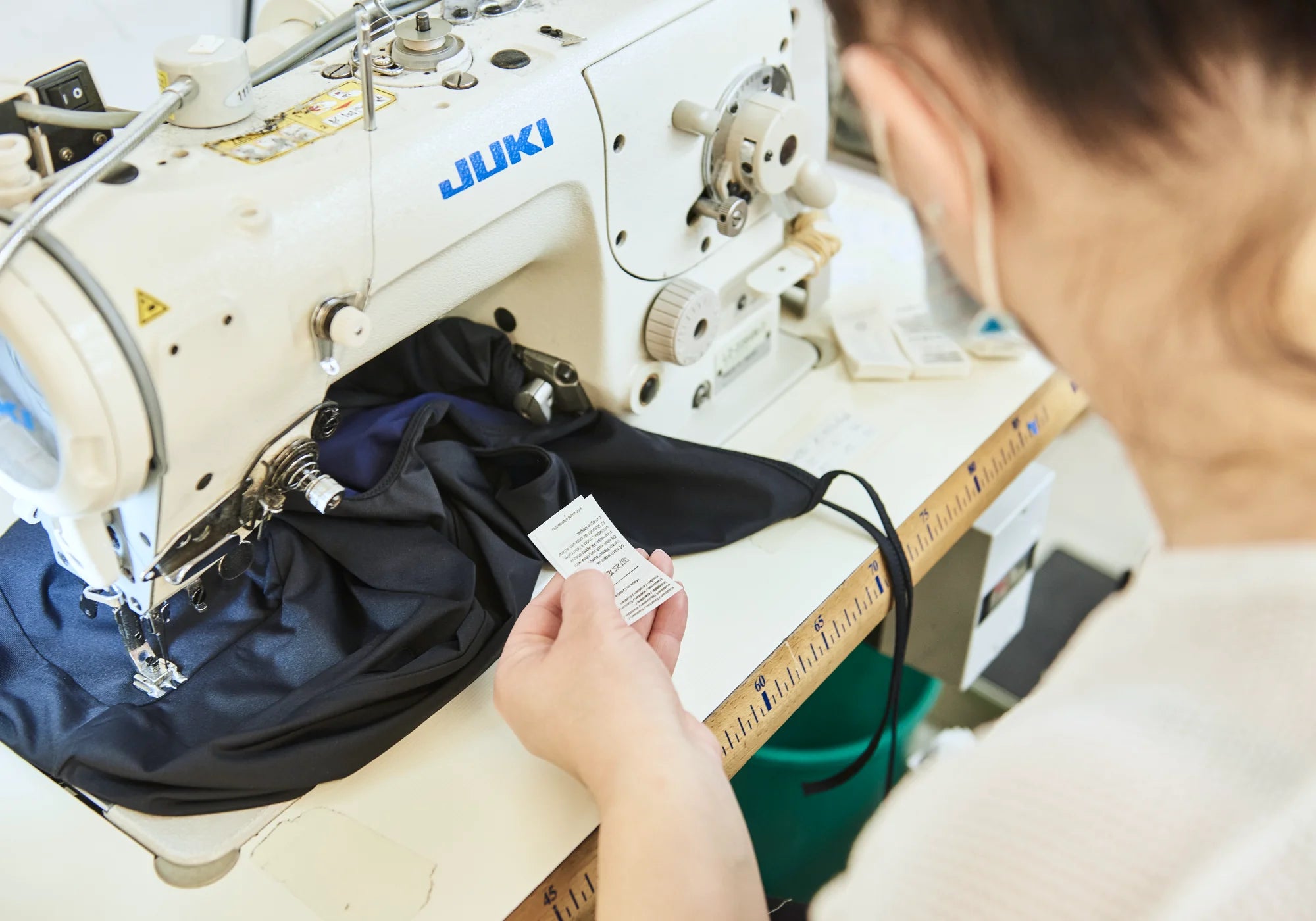 Person näht an einer Nähmaschine ein MYMARINI-Bikinitop mit breiten Trägern.