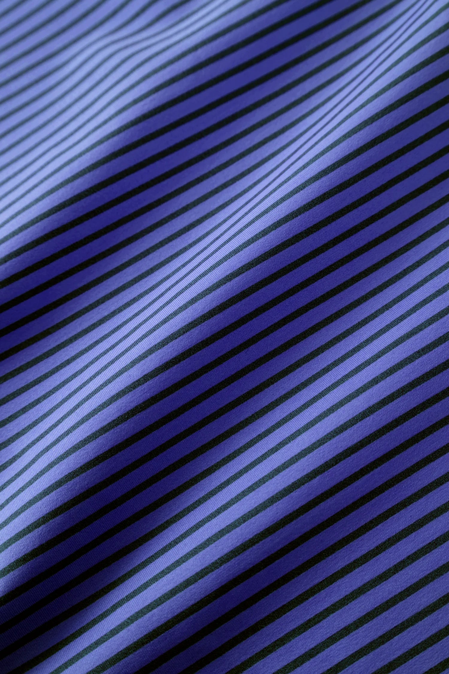 Stoff mit blauen und schwarzen Streifen, leicht gewellt.#color_blueberry-striped