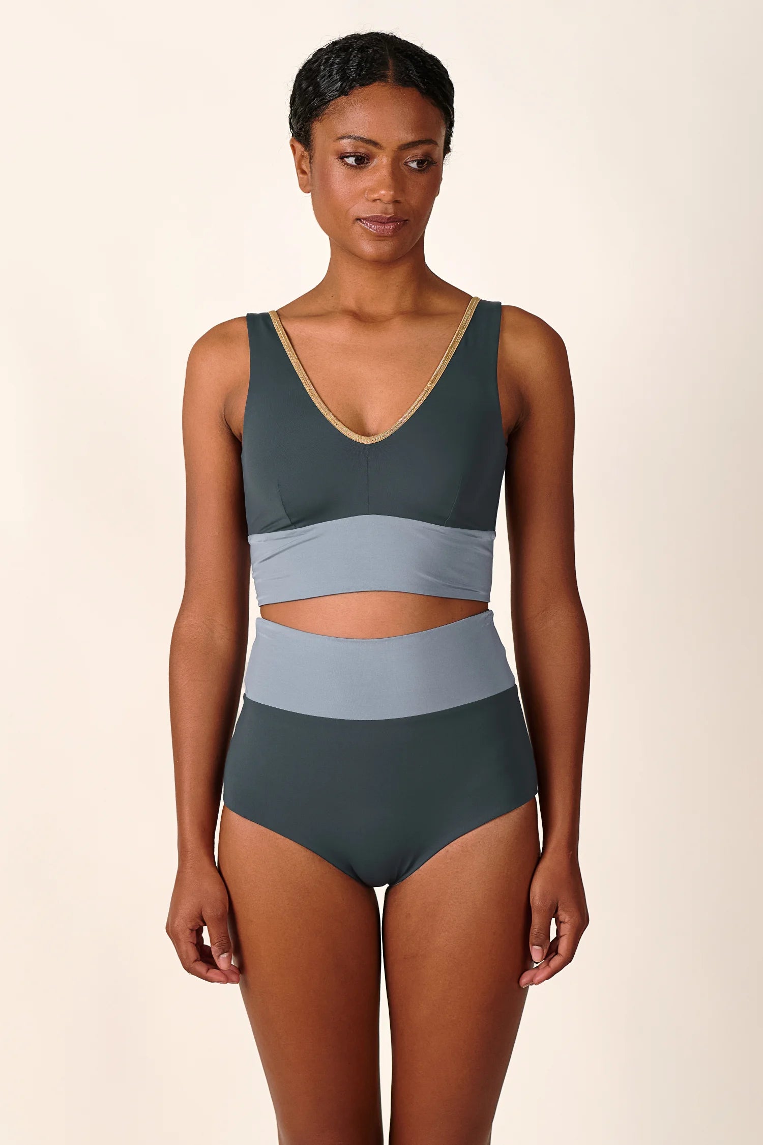 Frau trägt MYMARINI Bikini mit V-Ausschnitt und High Waist Schnitt in Dunkelgrau und Hellgrau.#color_crystal-grey