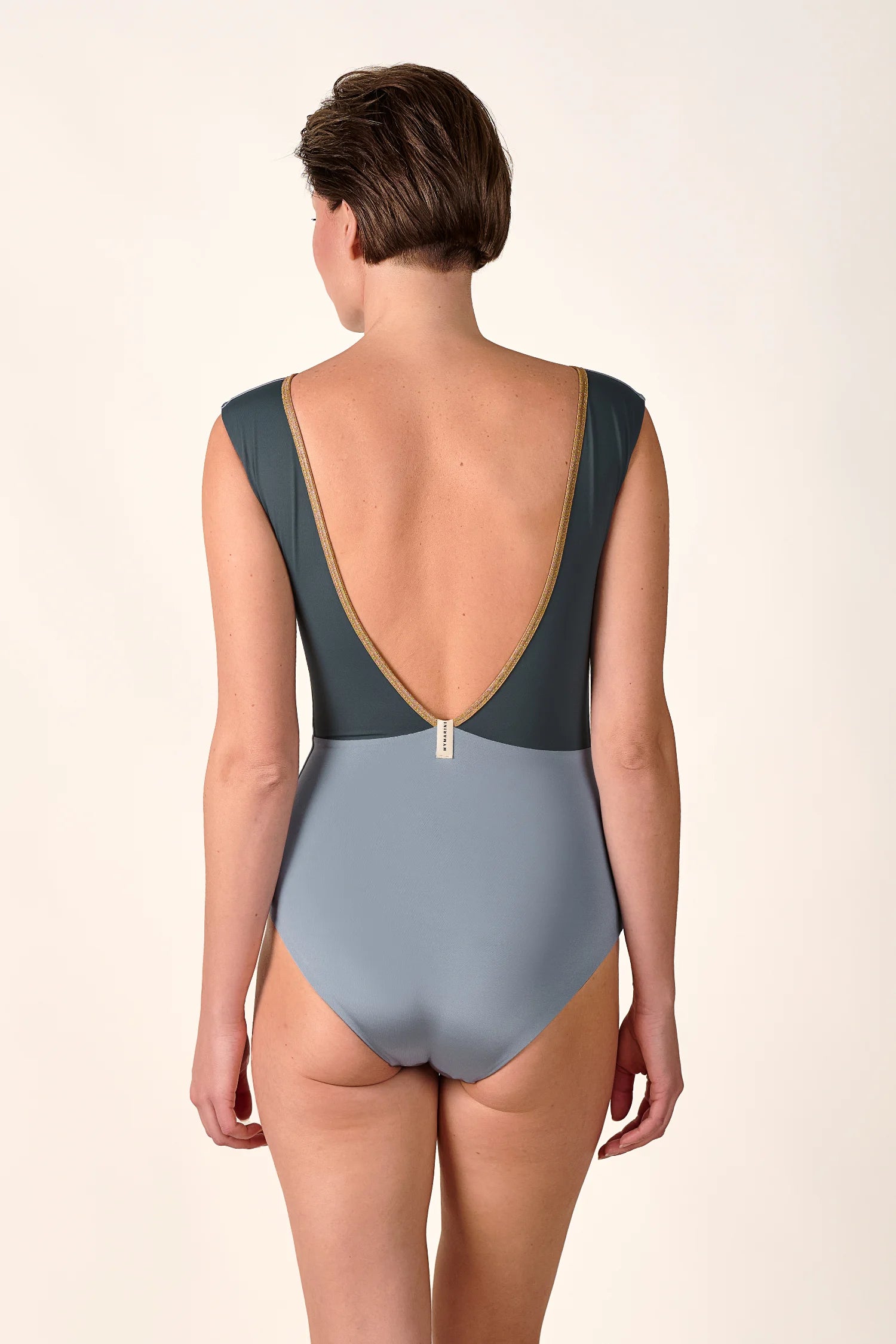 Rückansicht eines MYMARINI Badeanzugs mit tiefem Rückenausschnitt und breiten Trägern in zweifarbiger Optik.#color_crystal-grey