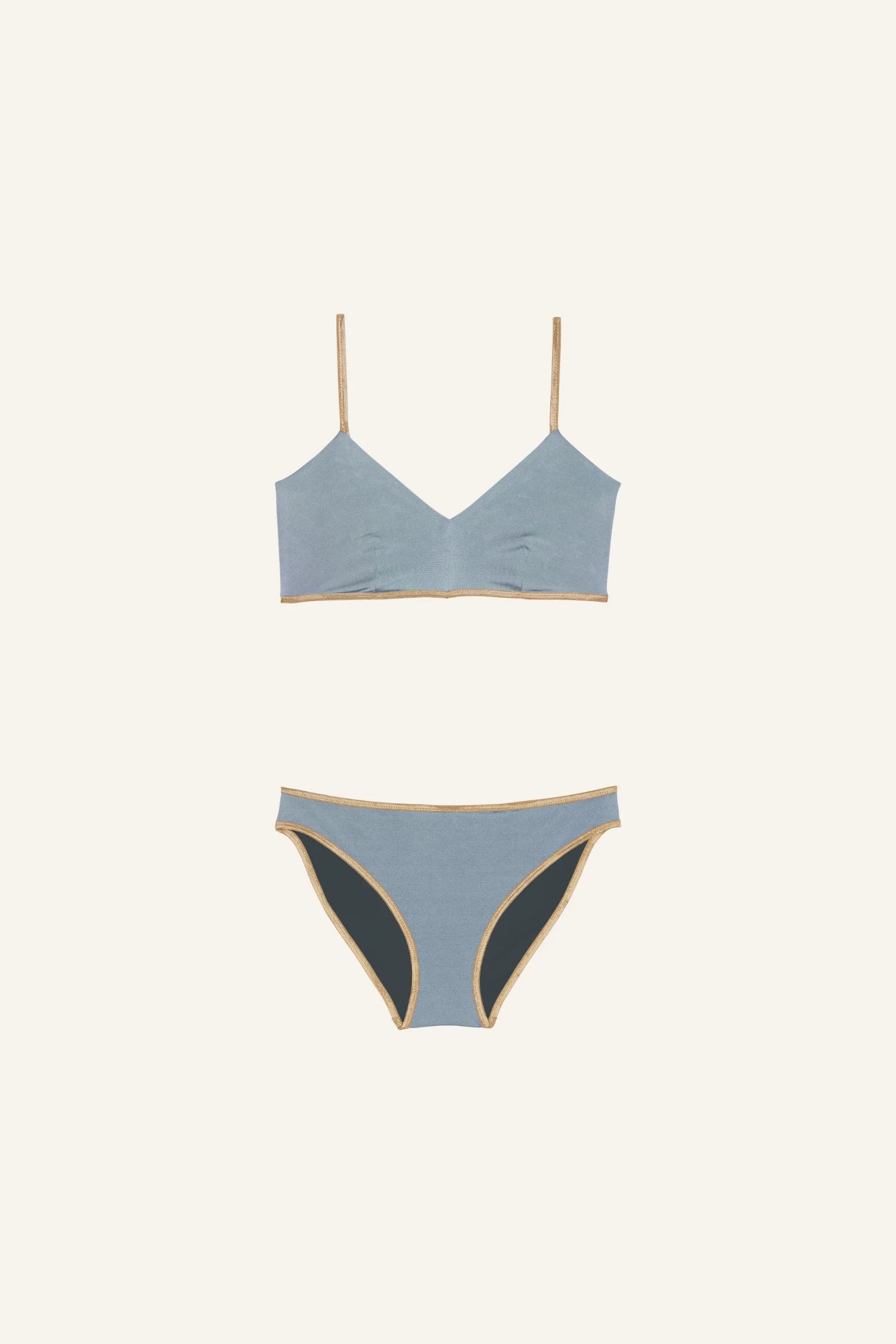 MYMARINI Bikini-Set mit Spaghettiträgern und hohem Beinausschnitt in Blau mit beigen Details auf hellem Hintergrund.#color_crystal-grey