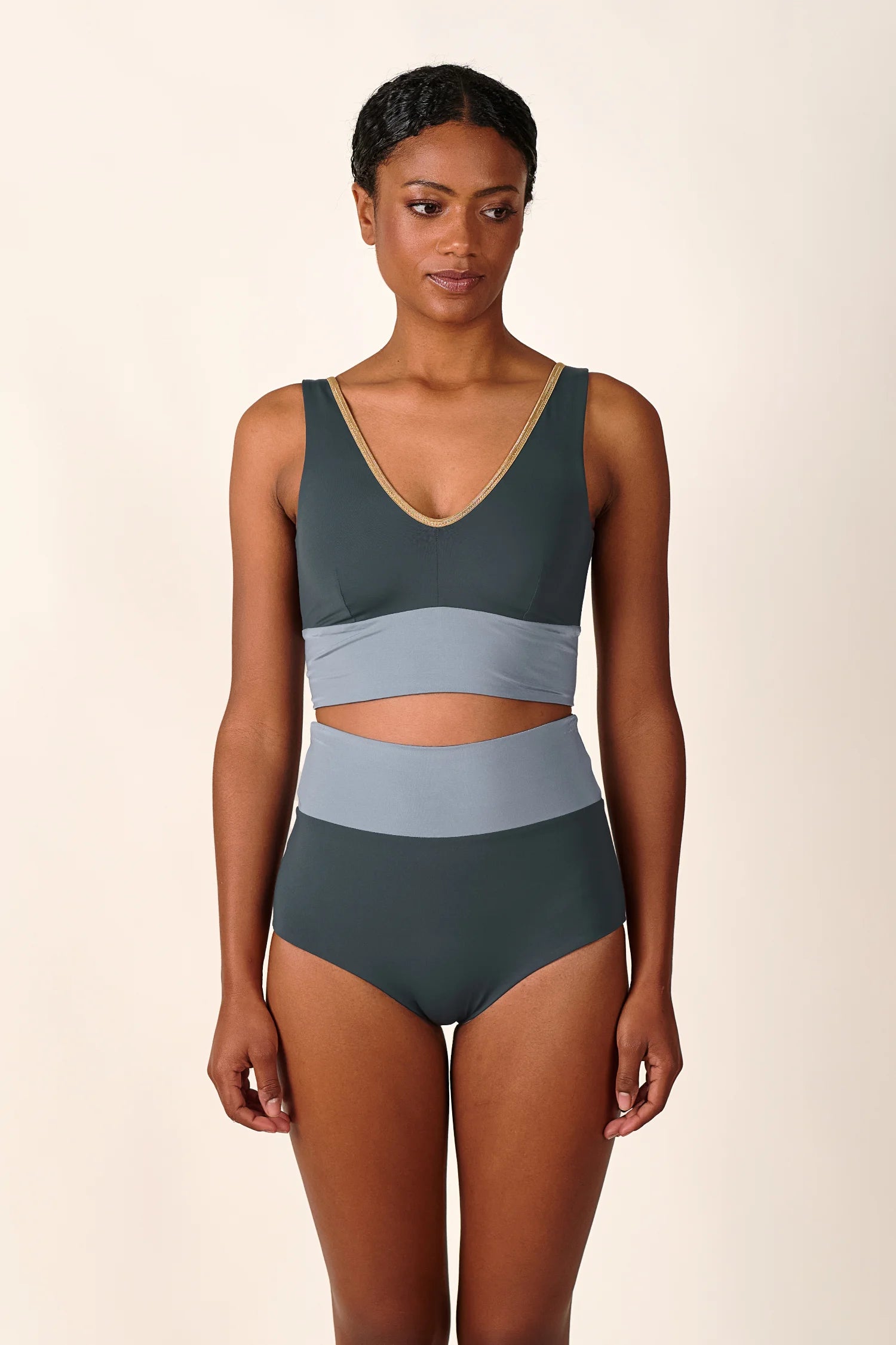 Frau trägt MYMARINI Bikini mit V-Ausschnitt und High Waist in Dunkelgrau und Hellgrau.#color_crystal-grey