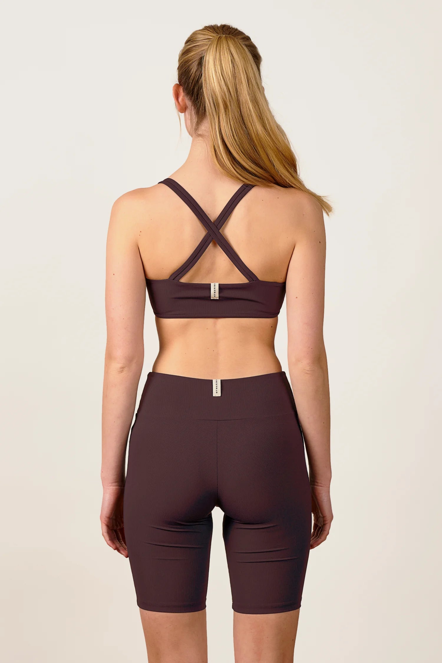 Rückansicht einer Frau in MYMARINI Bikinitop mit breiten Trägern und Shorts in Dunkelbraun.#color_chocolate