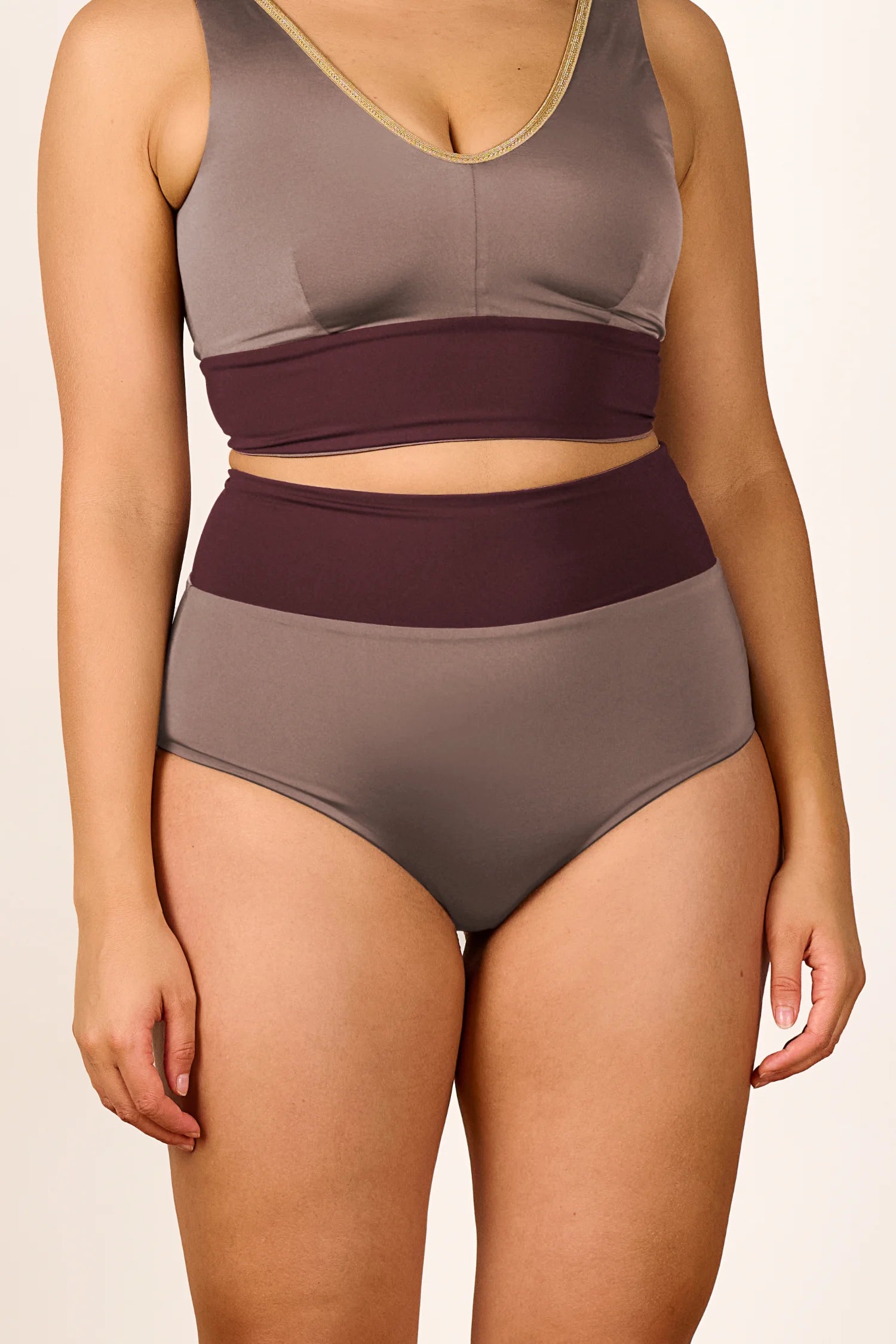 Frau trägt MYMARINI Bikini mit V-Ausschnitt und High Waist Hose in Braun- und Beigetönen.#color_shimmer-brown