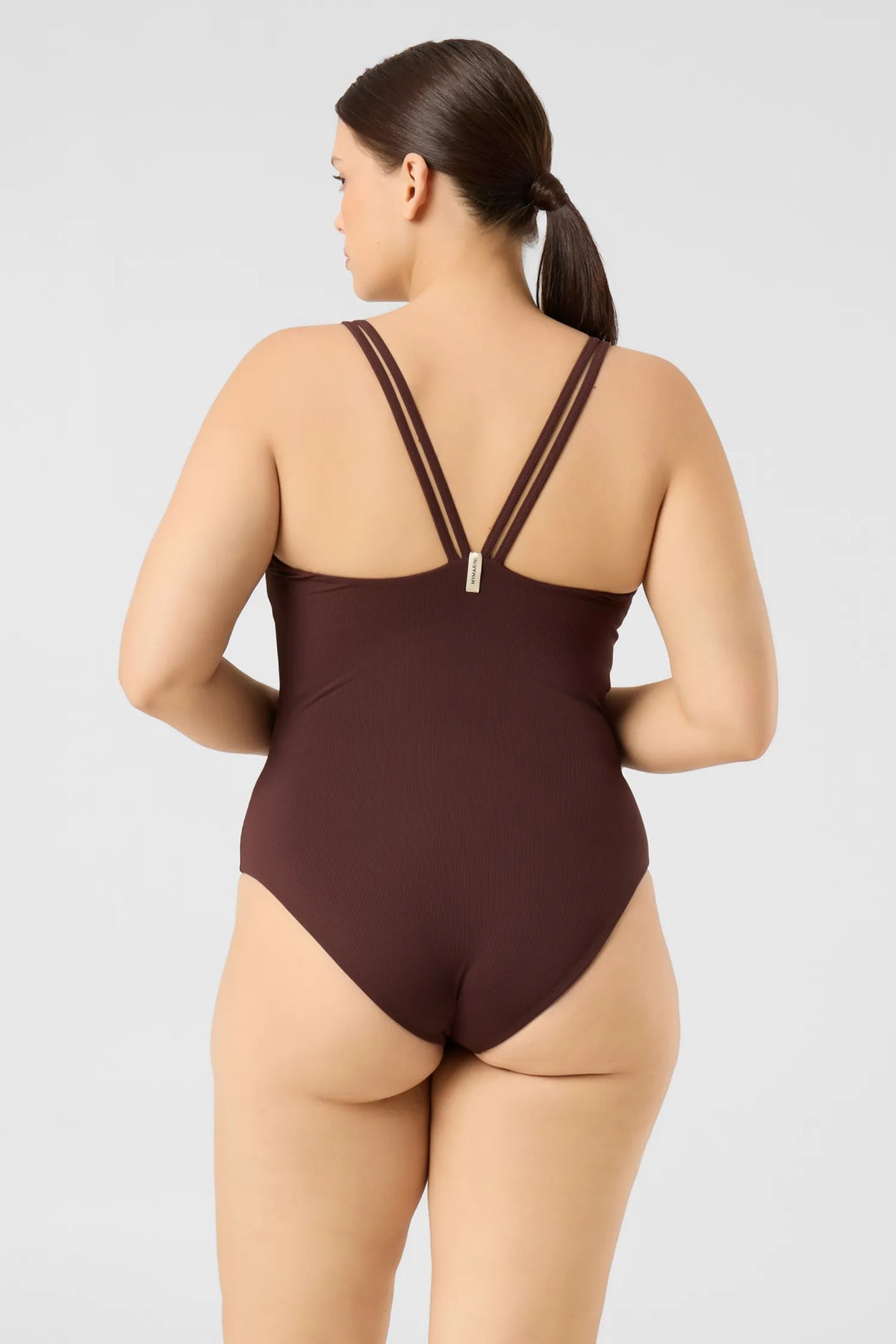 Back view of a woman in the MYMARINI CLEANSUIT swimsuit in chocolate, double straps meeting in a V#color_chocolate-ribbed