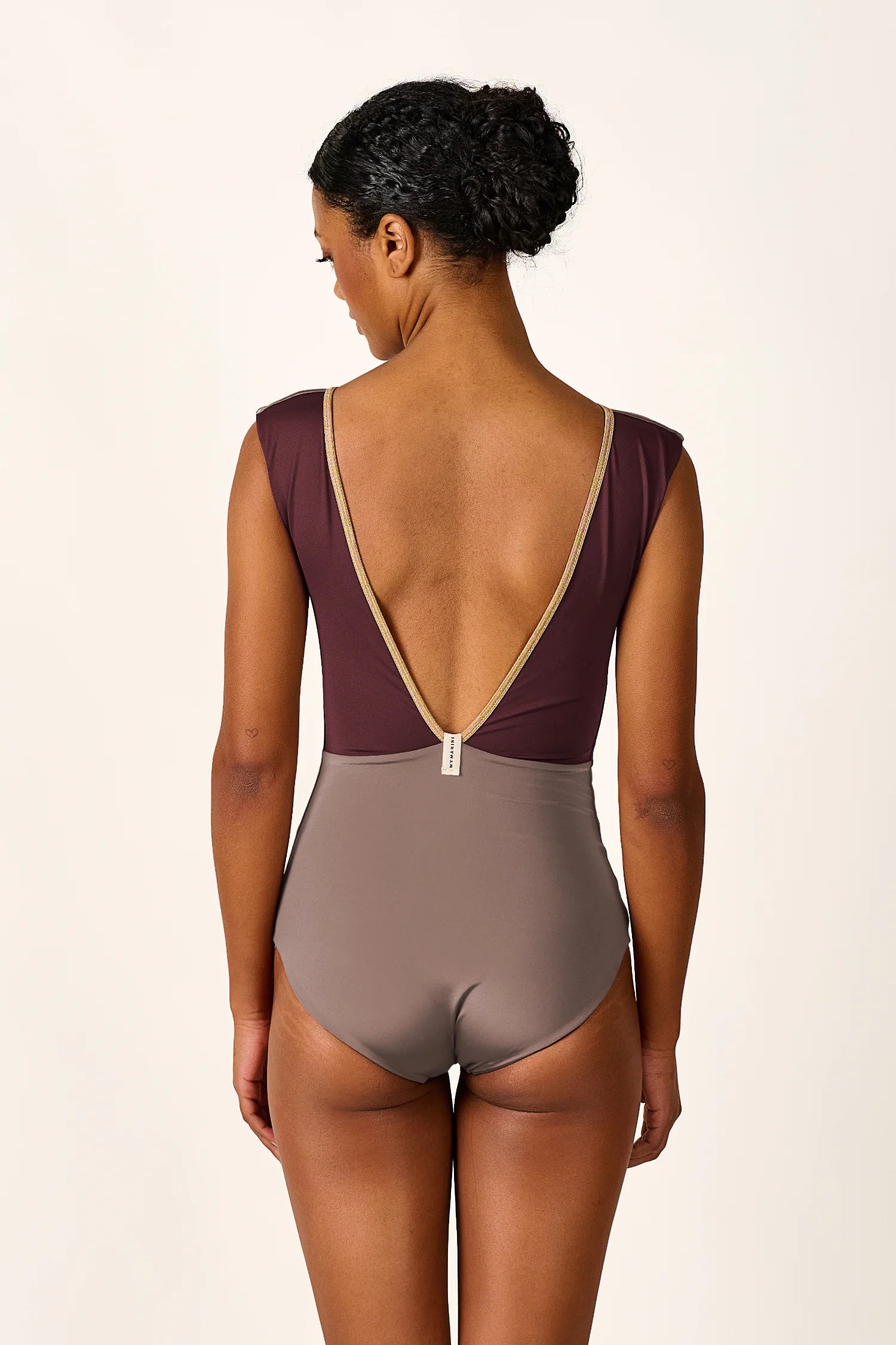 Rückansicht eines MYMARINI Badeanzugs mit tiefem Rückenausschnitt und breiten Trägern in Braun- und Beigetönen.#color_shimmer-brown