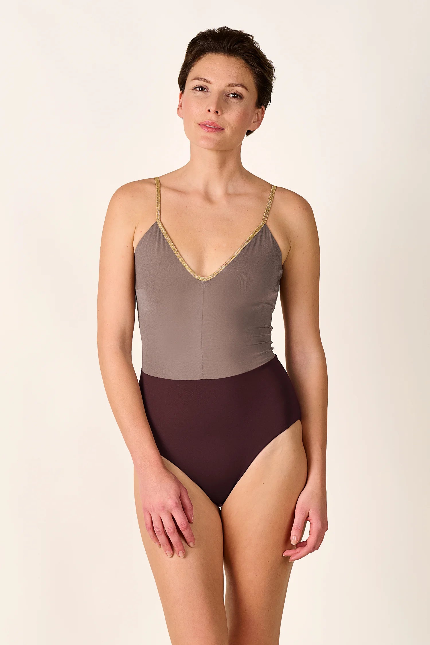 Person trägt MYMARINI Badeanzug mit V-Ausschnitt und hohem Beinausschnitt in zweifarbiger Optik.#color_shimmer-brown
