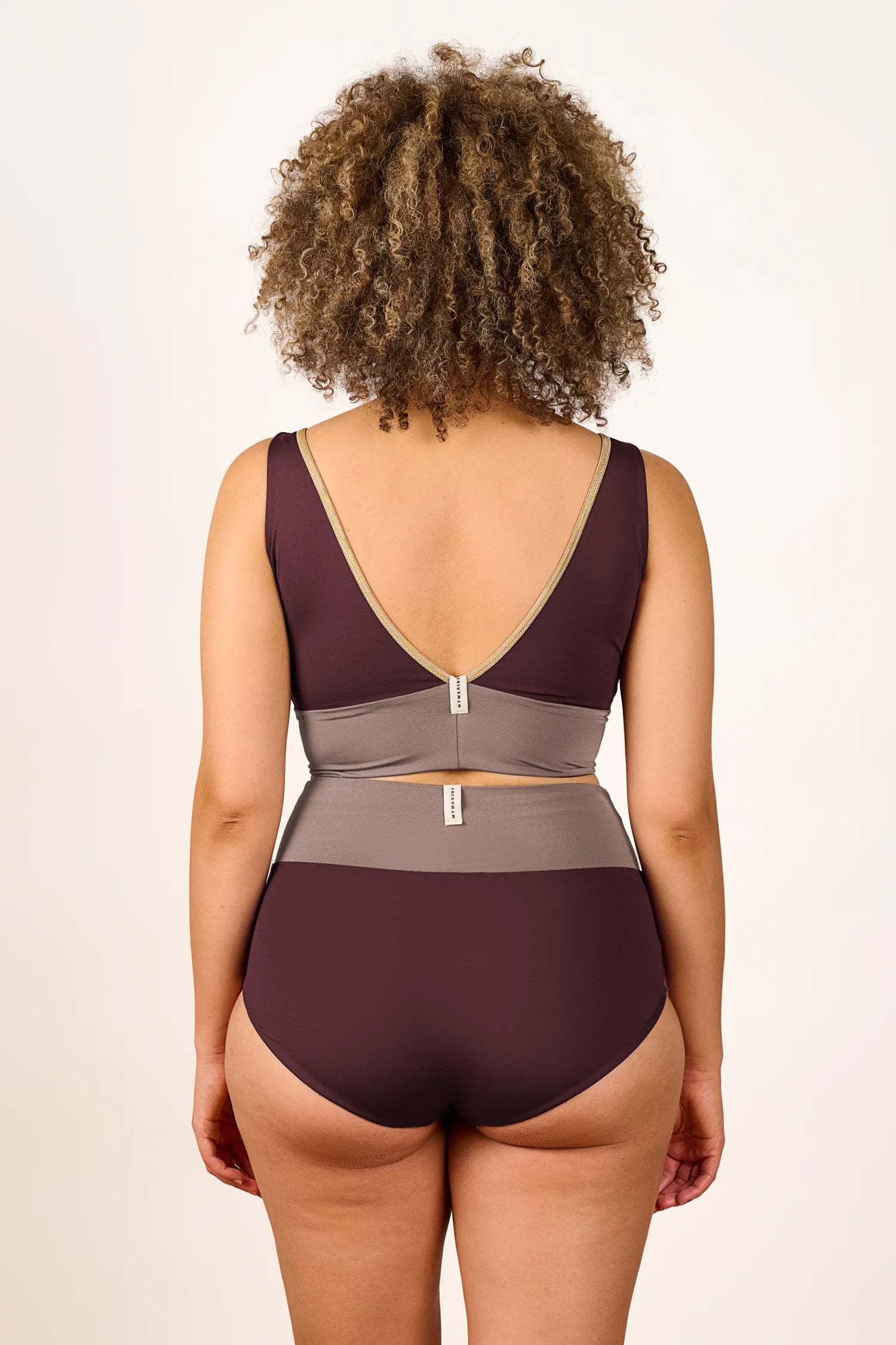 Rückansicht eines MYMARINI Badeanzugs mit V-Ausschnitt und hohem Beinausschnitt in Braun und Grau.#color_shimmer-brown