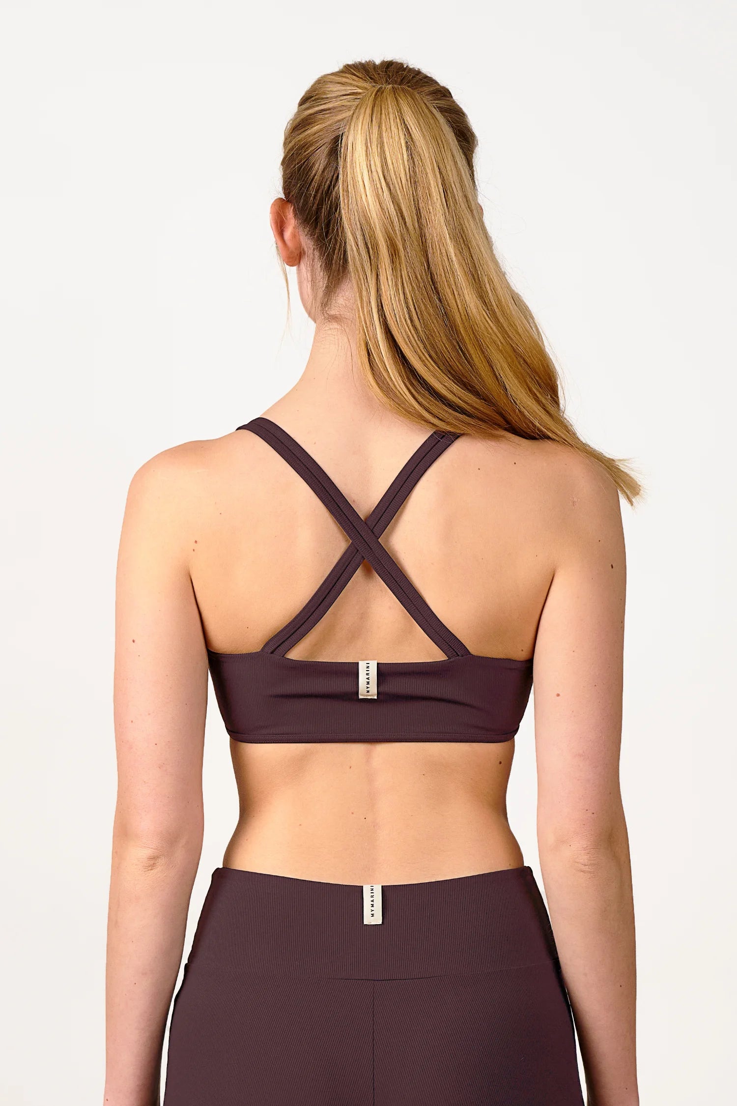 Frau in braunem MYMARINI Cross Top mit breiten Trägern und passender Bikinihose, Rückansicht.#color_chocolate