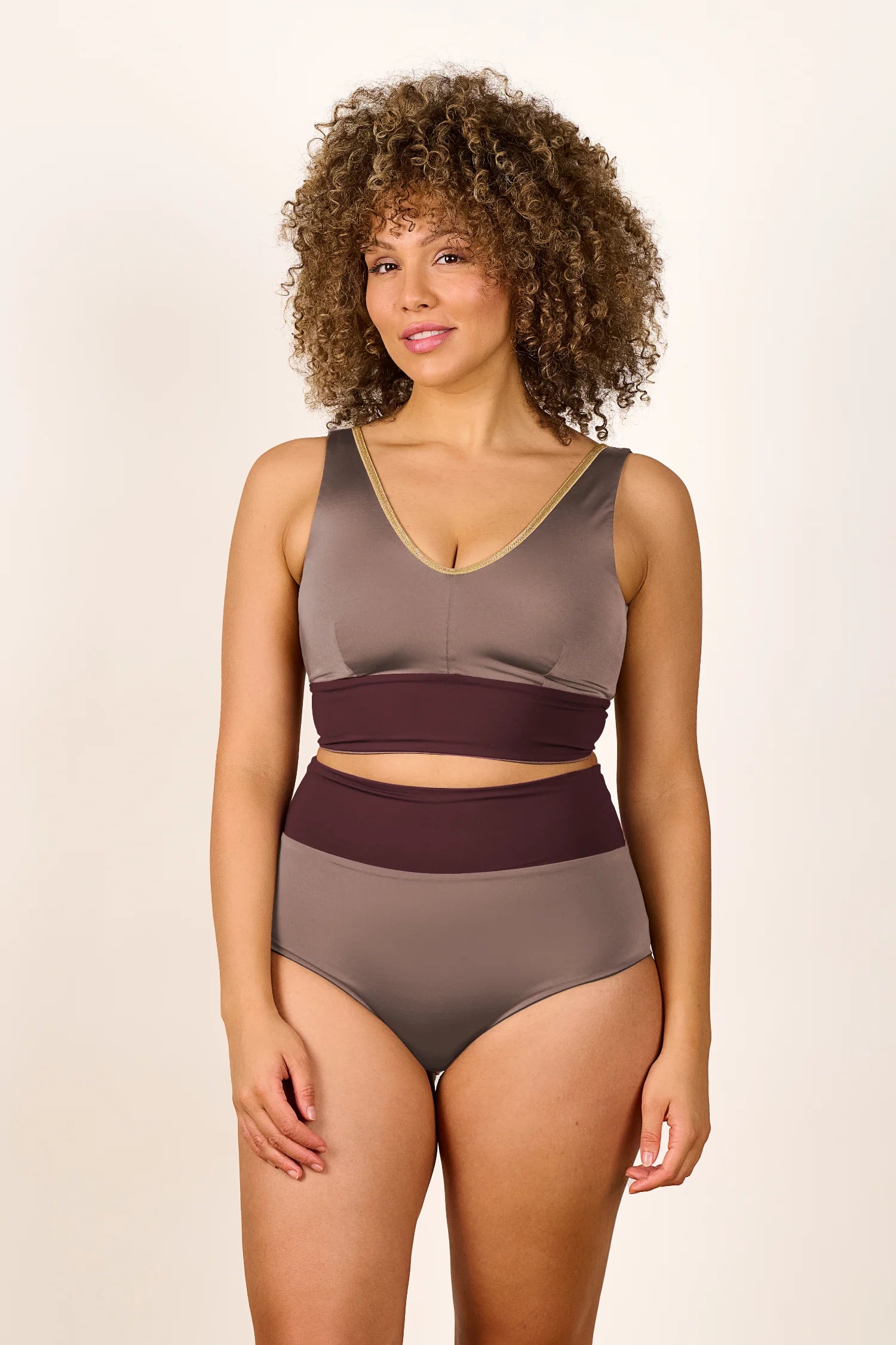 Frau trägt MYMARINI Bikinitop mit V-Ausschnitt und Bikinihose mit High Waist in Erdtönen.#color_shimmer-brown