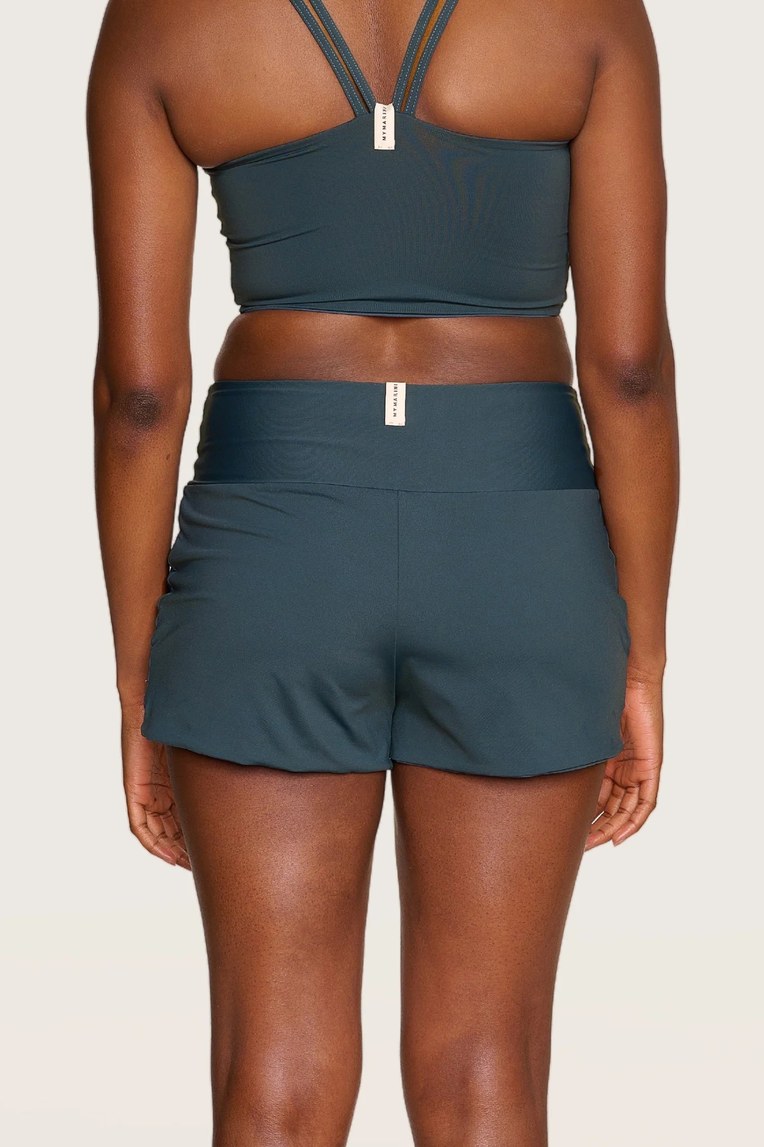 Person von hinten in MYMARINI Bikinitop mit breiten Trägern und Shorts.#color_grey