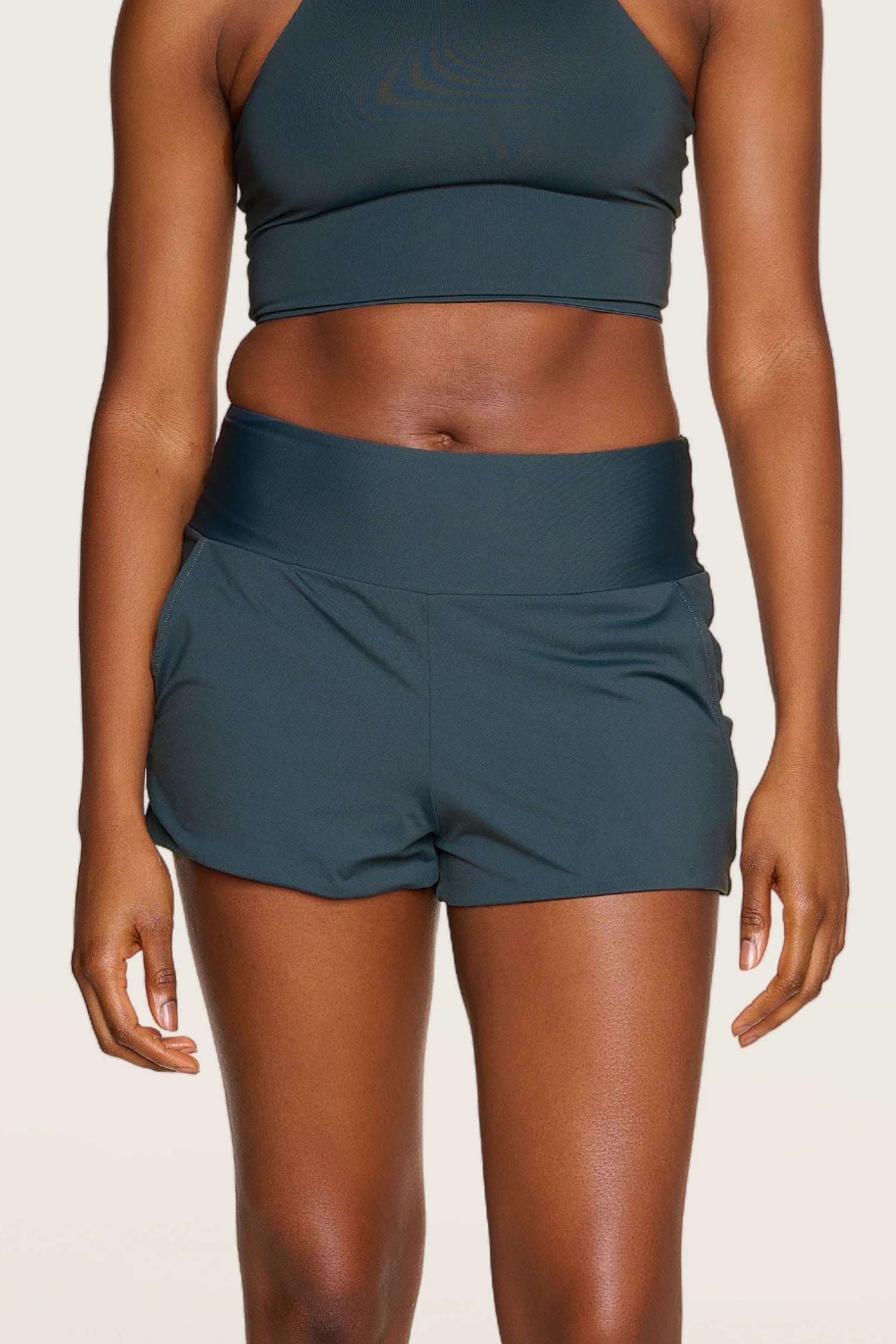 Person trägt MYMARINI-Shorts mit breitem Bund und passendem Top.#color_grey