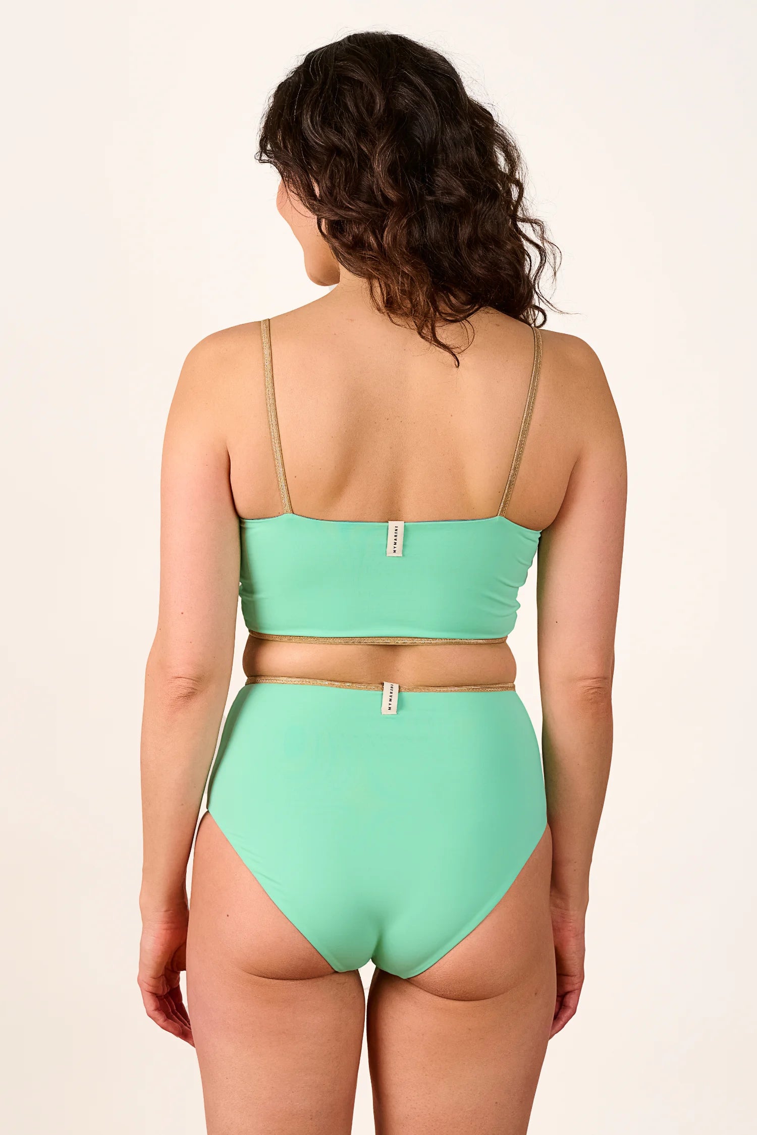 Frau in MYMARINI Bikini mit Spaghettiträgern und High-Waist-Schnitt in Mintgrün, Rückansicht.#color_lagoon-teal