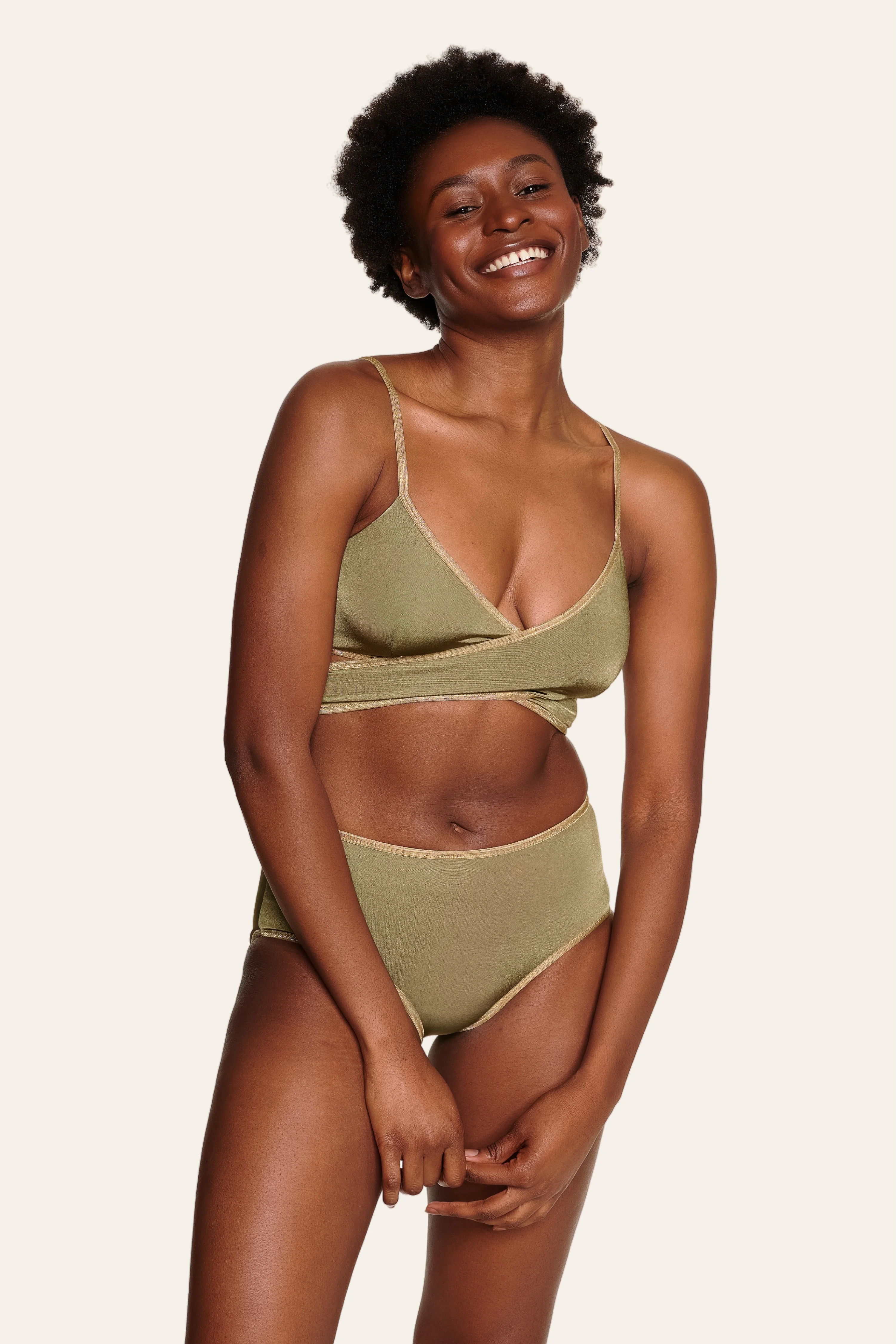 Lächelnde Person trägt MYMARINI Bikinitop mit V-Ausschnitt und Bikinihose in Mid rise.#color_apple-leaves