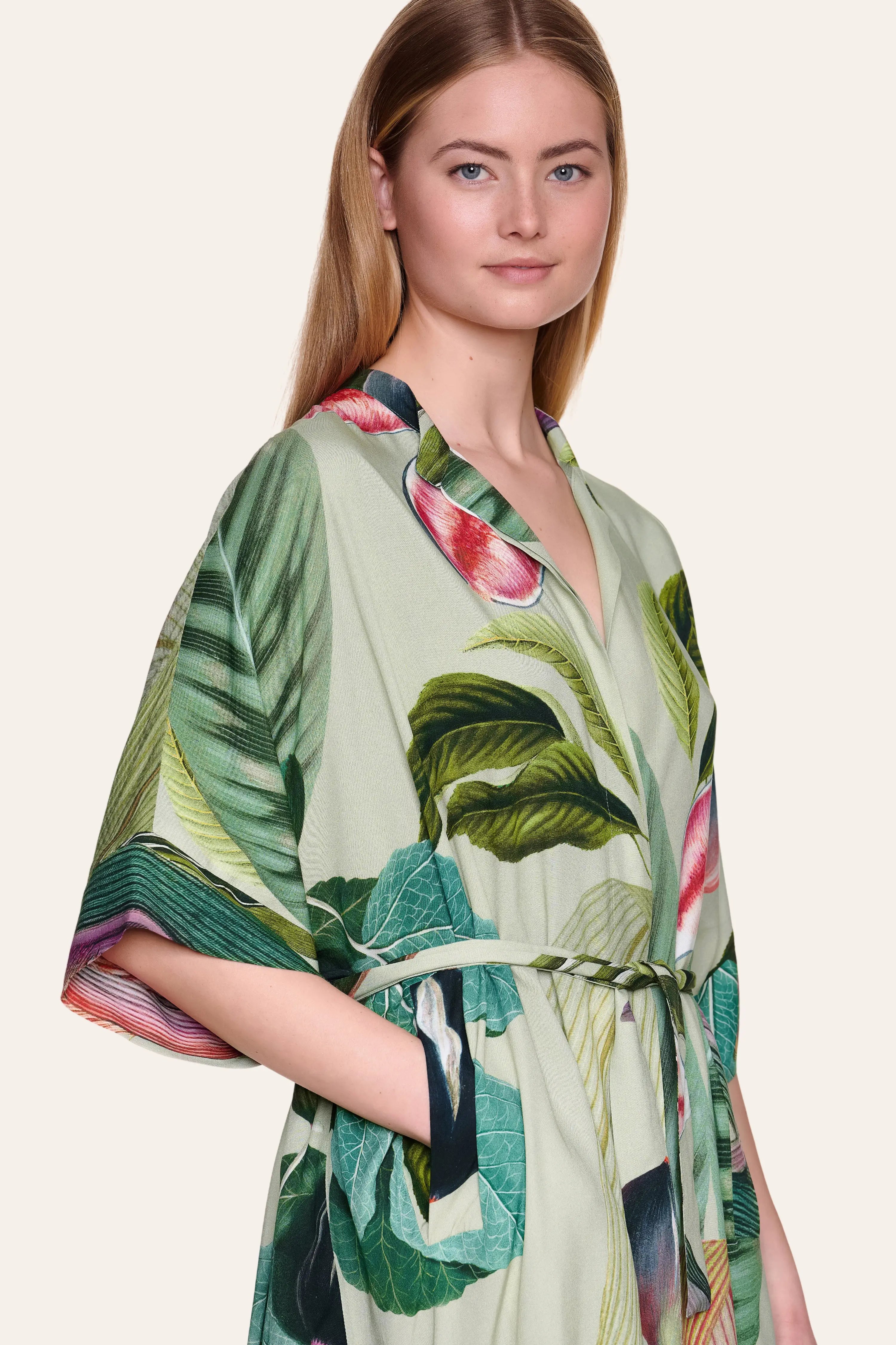 Frau trägt MYMARINI-Kleid mit tropischem Muster und Gürtel.#color_tropical-print