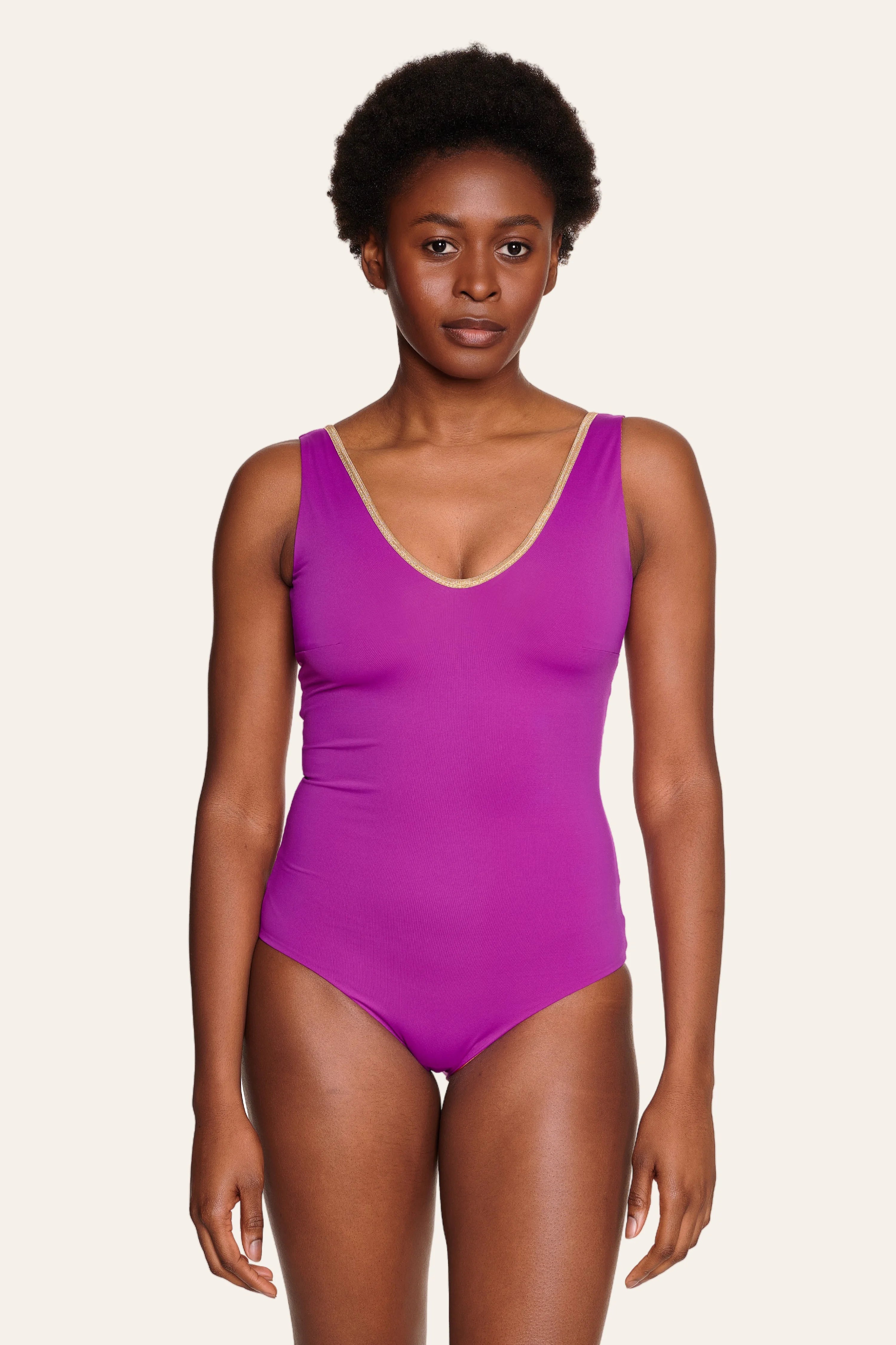 Person trägt einen MYMARINI Badeanzug in Lila mit V-Ausschnitt und breiten Trägern.#color_papaya-cassis