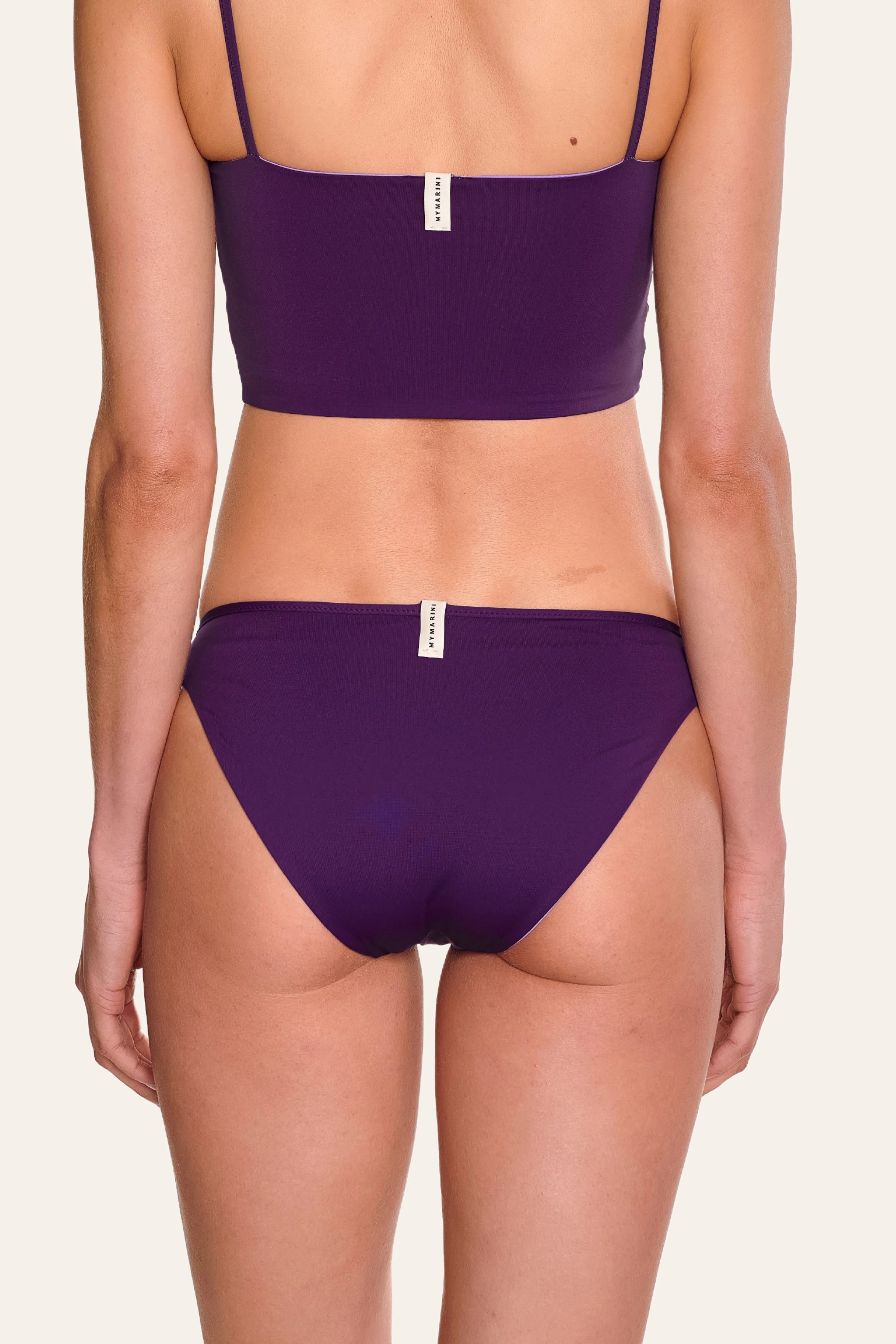 Rückansicht eines lila MYMARINI Bikinis mit Spaghettiträgern und hohem Beinausschnitt.#color_lavender-plum