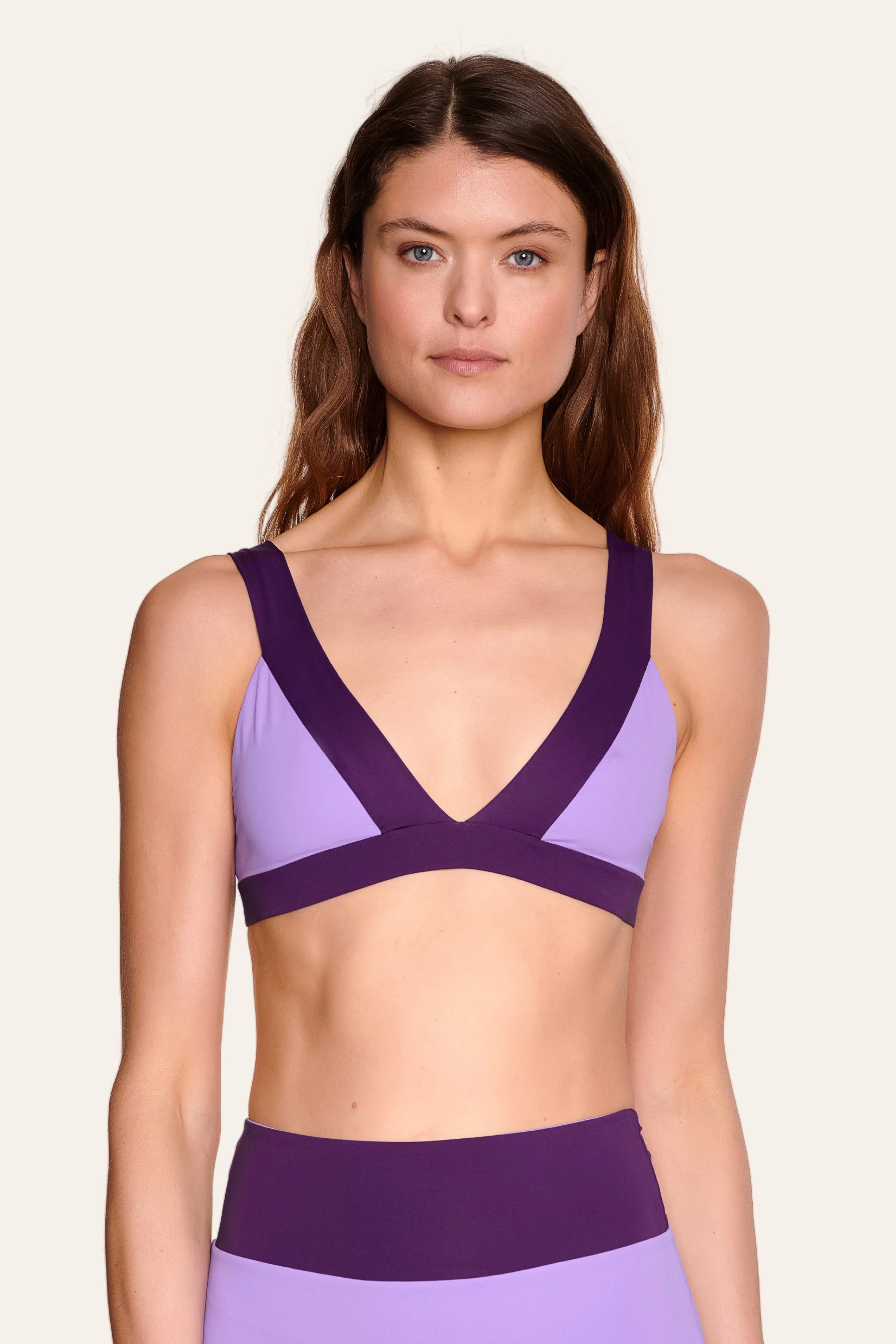 Frau trägt MYMARINI Bikinitop mit V-Ausschnitt und breiten Trägern in Lila.#color_lavender-plum