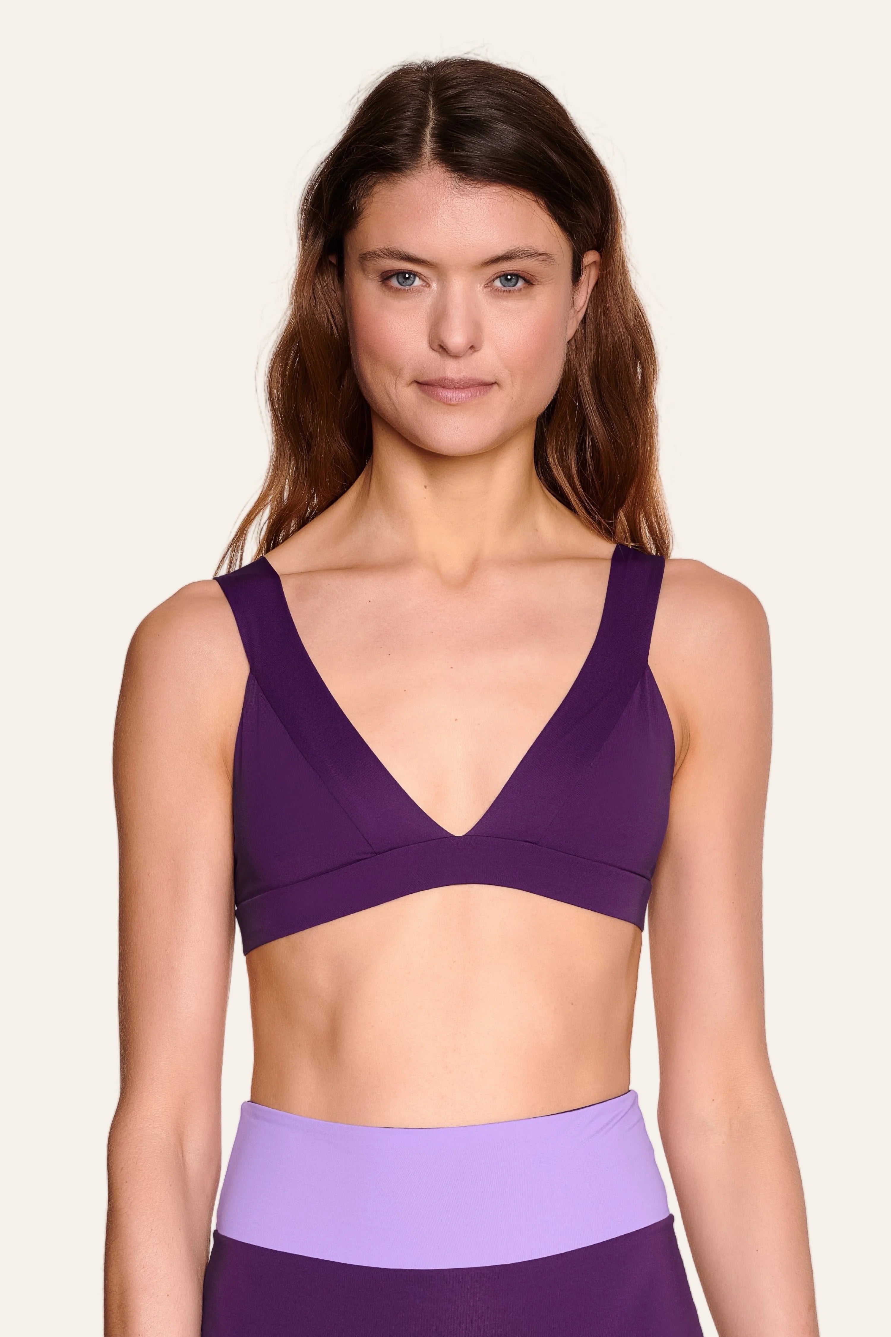Frau trägt MYMARINI Bikinitop mit V-Ausschnitt und breiten Trägern in Lila.#color_lavender-plum