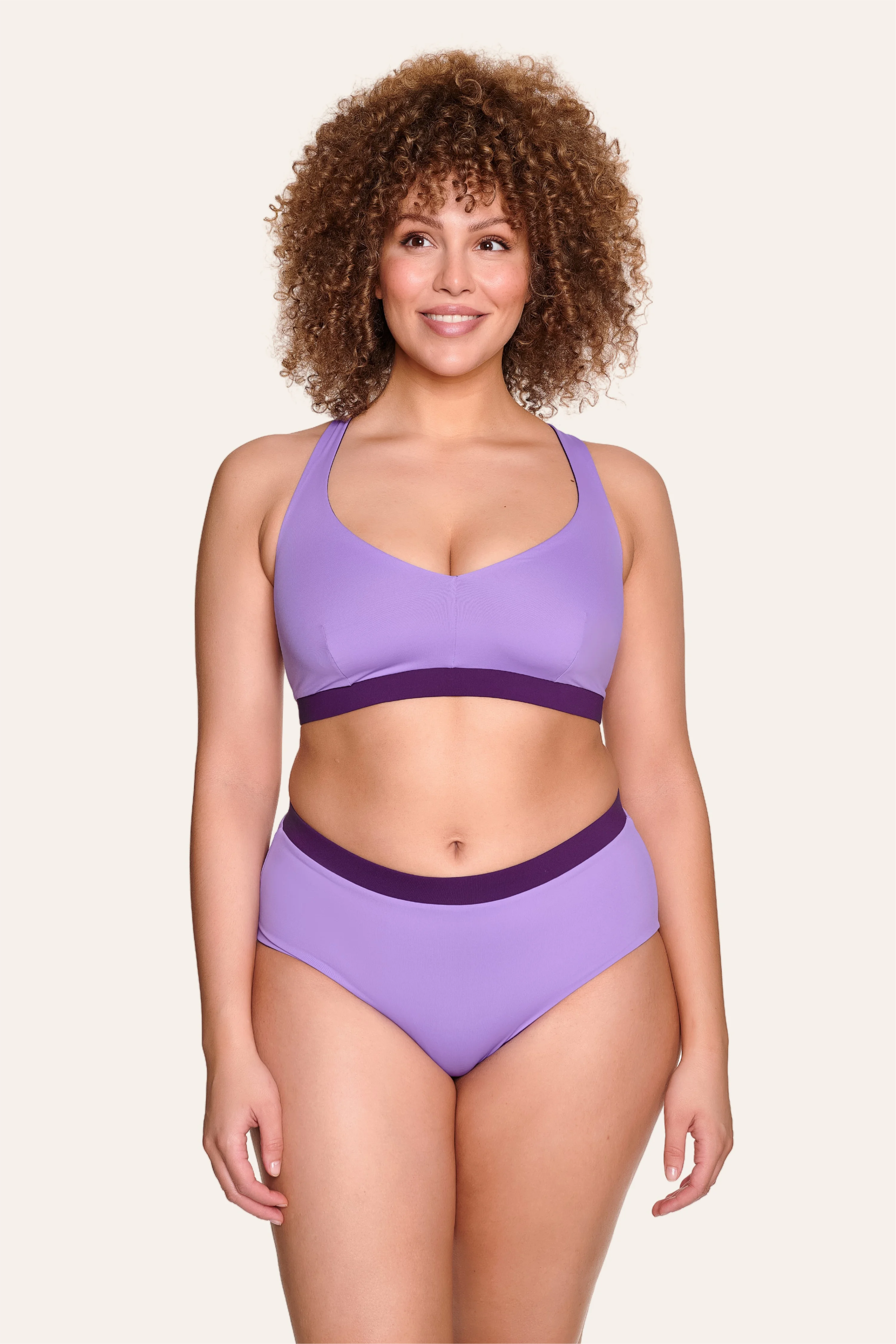 Frau trägt MYMARINI Bikini mit V-Ausschnitt und breiten Trägern in Lila.#color_lavender-plum