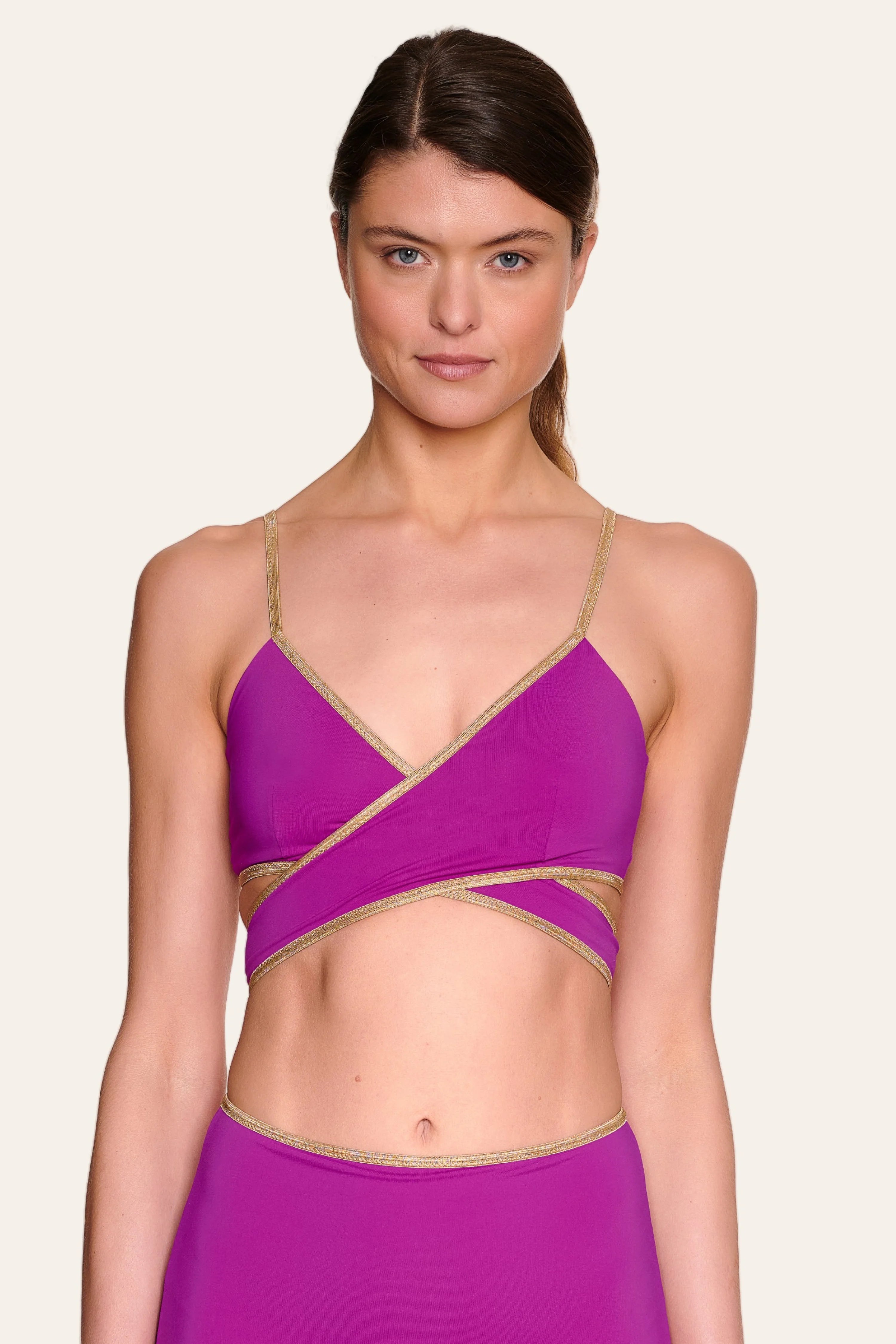 Frau trägt MYMARINI Bikinitop mit Spaghettiträgern und Cross-Top-Schnitt in Lila.#color_papaya-cassis
