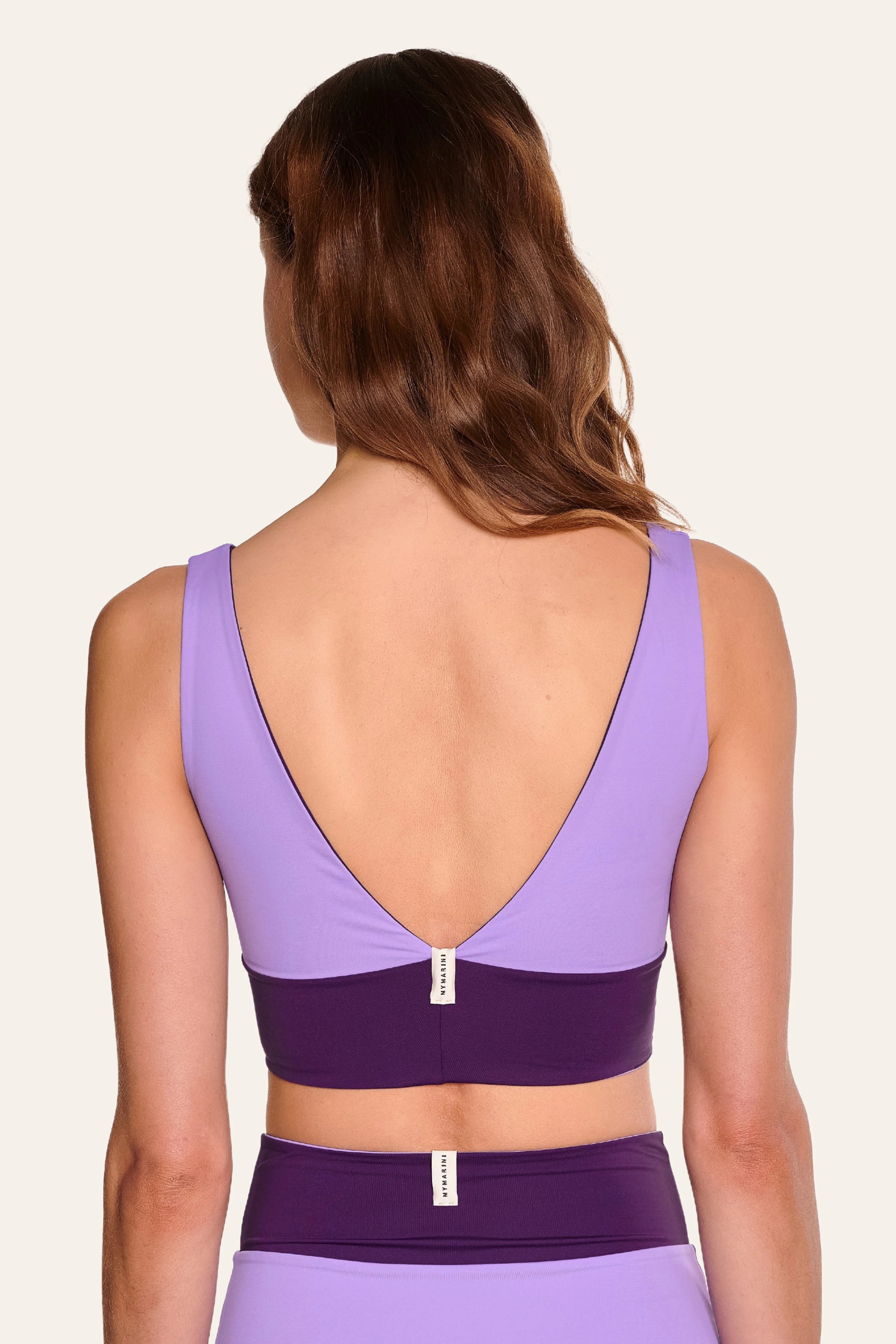 Frau in lila MYMARINI Bikinitop mit tiefem Rückenausschnitt und breiten Trägern, dazu passende Bikinihose.#color_lavender-plum
