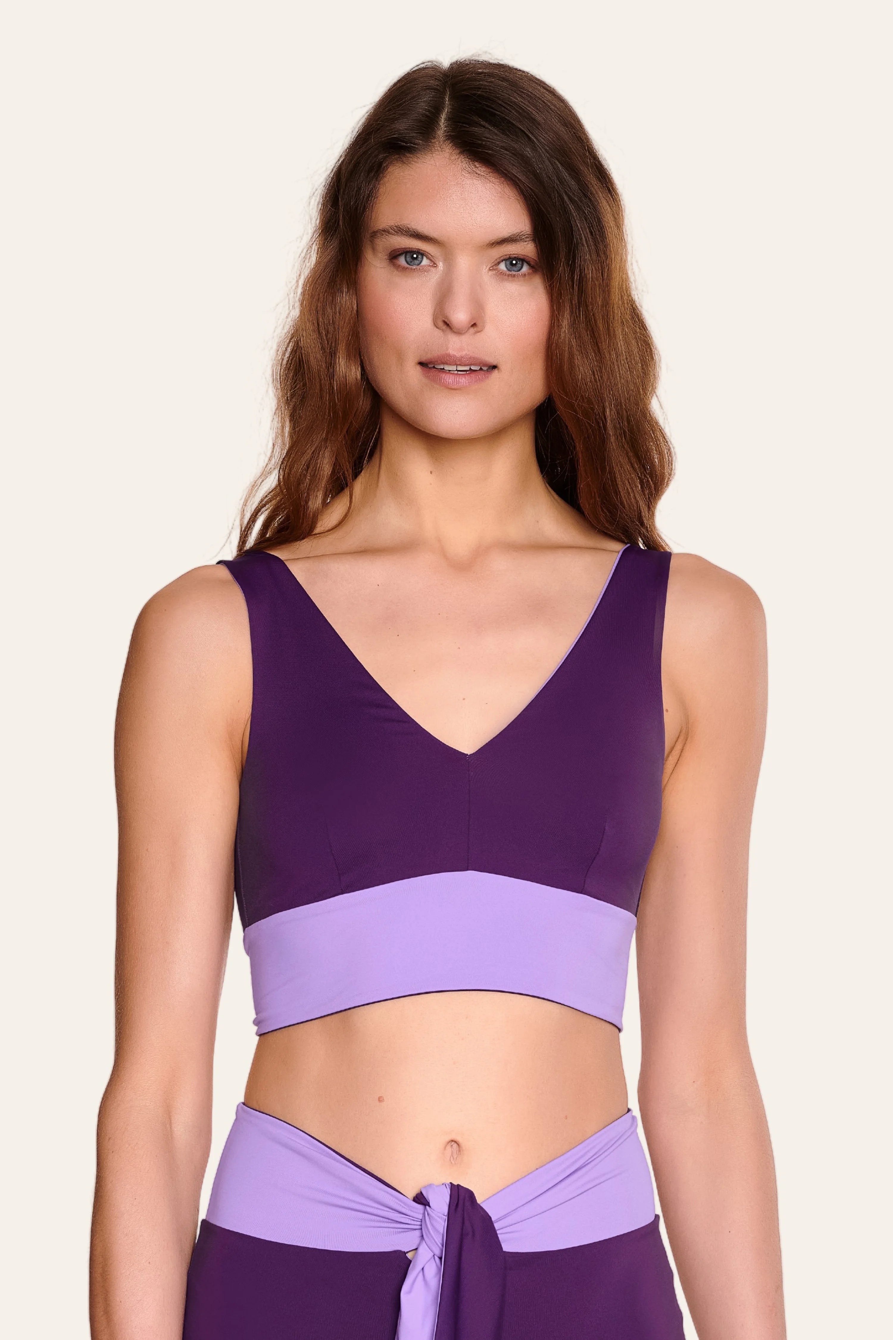 Frau trägt MYMARINI Bikinitop mit V-Ausschnitt in Lila.#color_lavender-plum