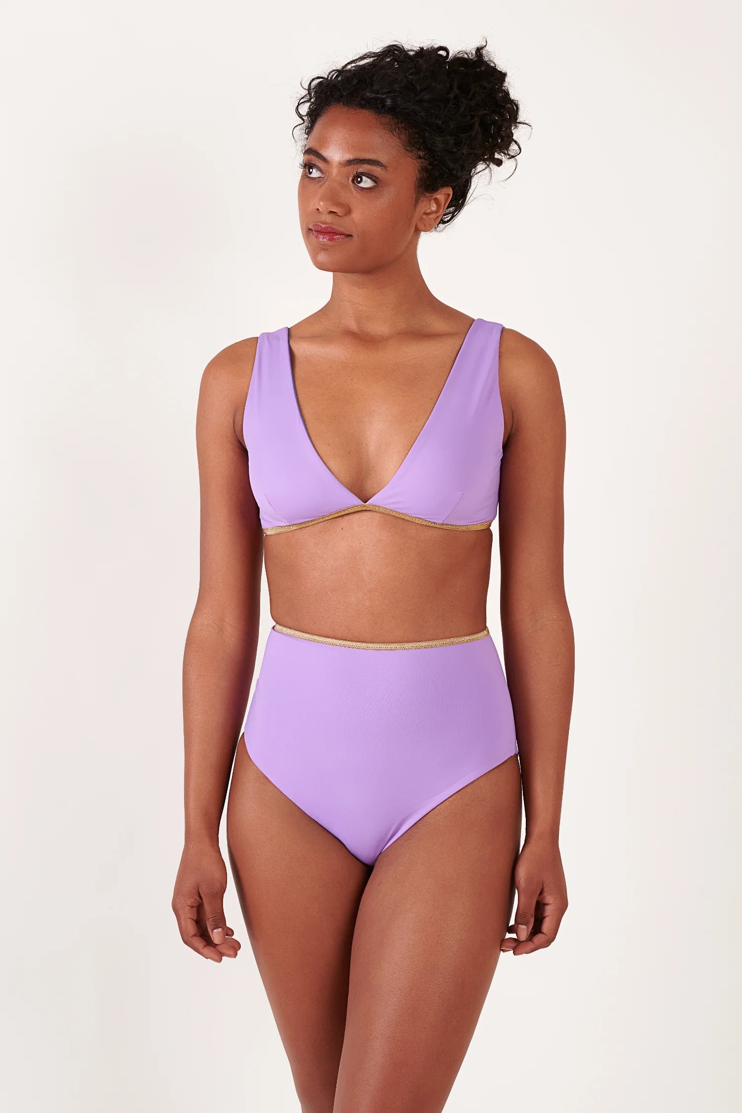 MYMARINI Bikinioberteil und Bikinihose in Lavendel, V-Ausschnitt, breite Träger, High-Waist, goldene Ziernaht, frontal stehende Frau.#color_lapis-lavender