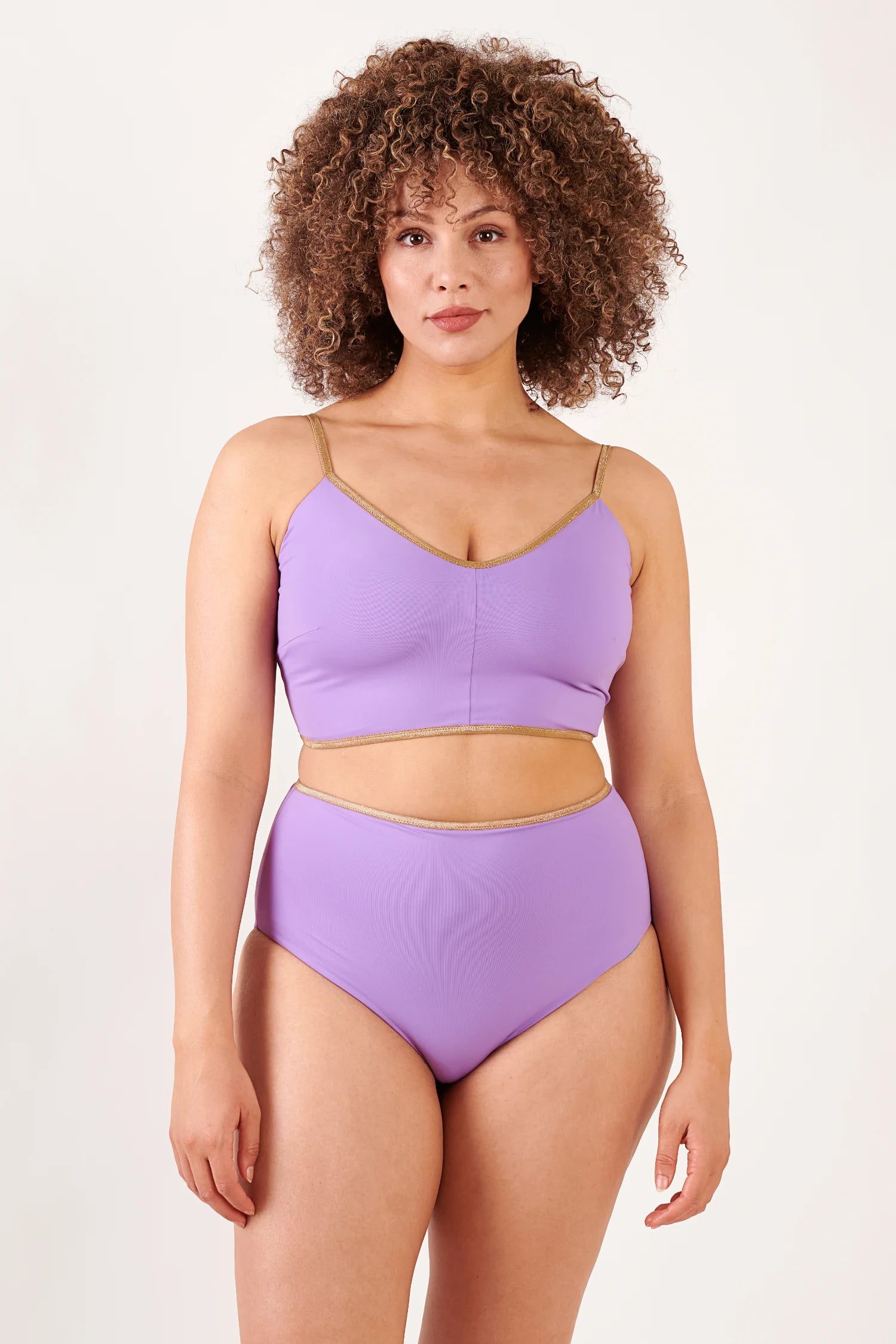MYMARINI Bikinitop (Spaghettiträger, V-Ausschnitt) und Bikinihose High-Waist in Flieder mit goldener Ziernaht, getragen von einer Frau.#color_lapis-lavender