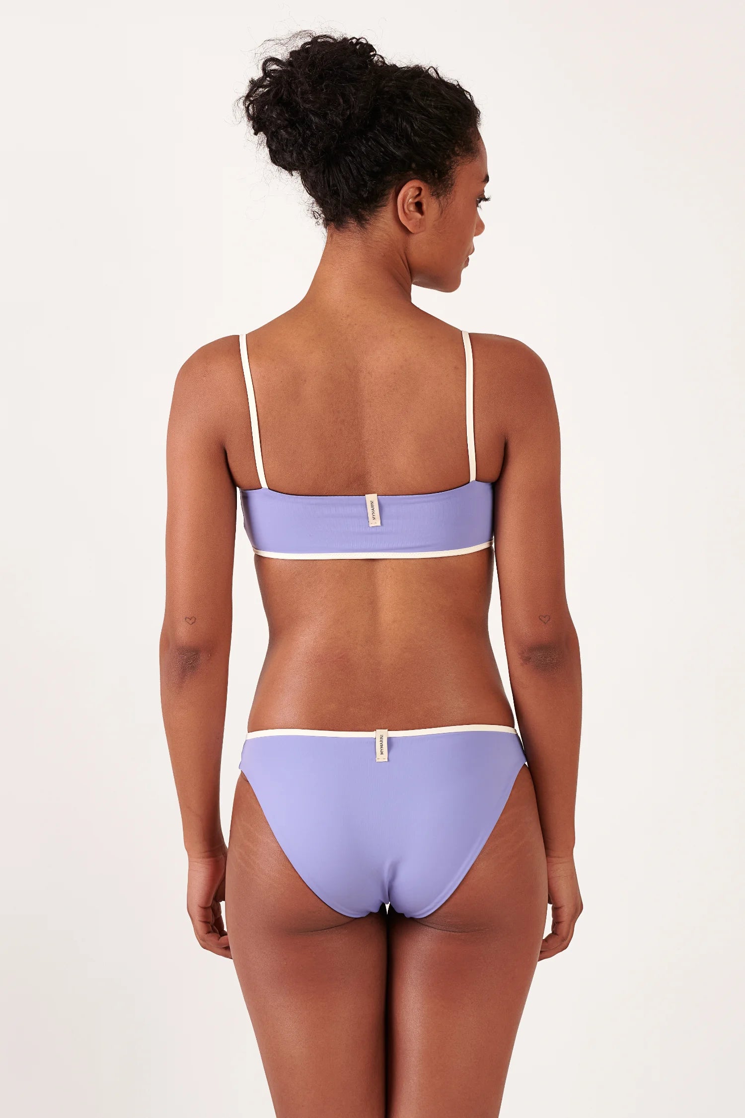 MYMARINI Bikini-Top in Lavendel mit Spaghettiträgern und weißem Rand; passendes Unterteil mit Label, Rückenansicht, Mid rise.#color_chocolate-lilac