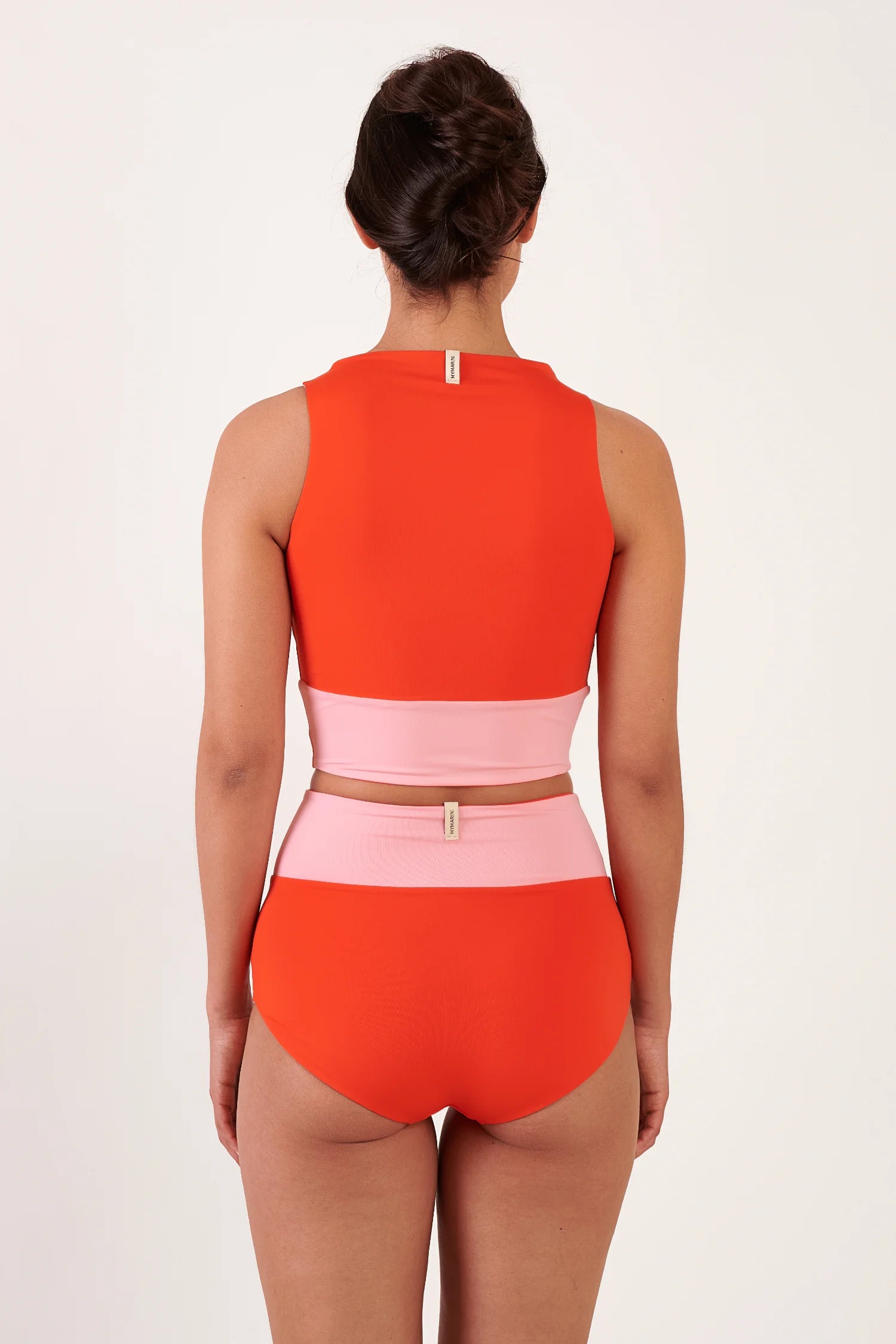 MYMARINI Bikinioberteil in Orange, hochgeschlossen am Rücken, passende pinke High-Waist-Bikinihose; Rückenansicht, Etikett sichtbar.#color_poppy-macaron