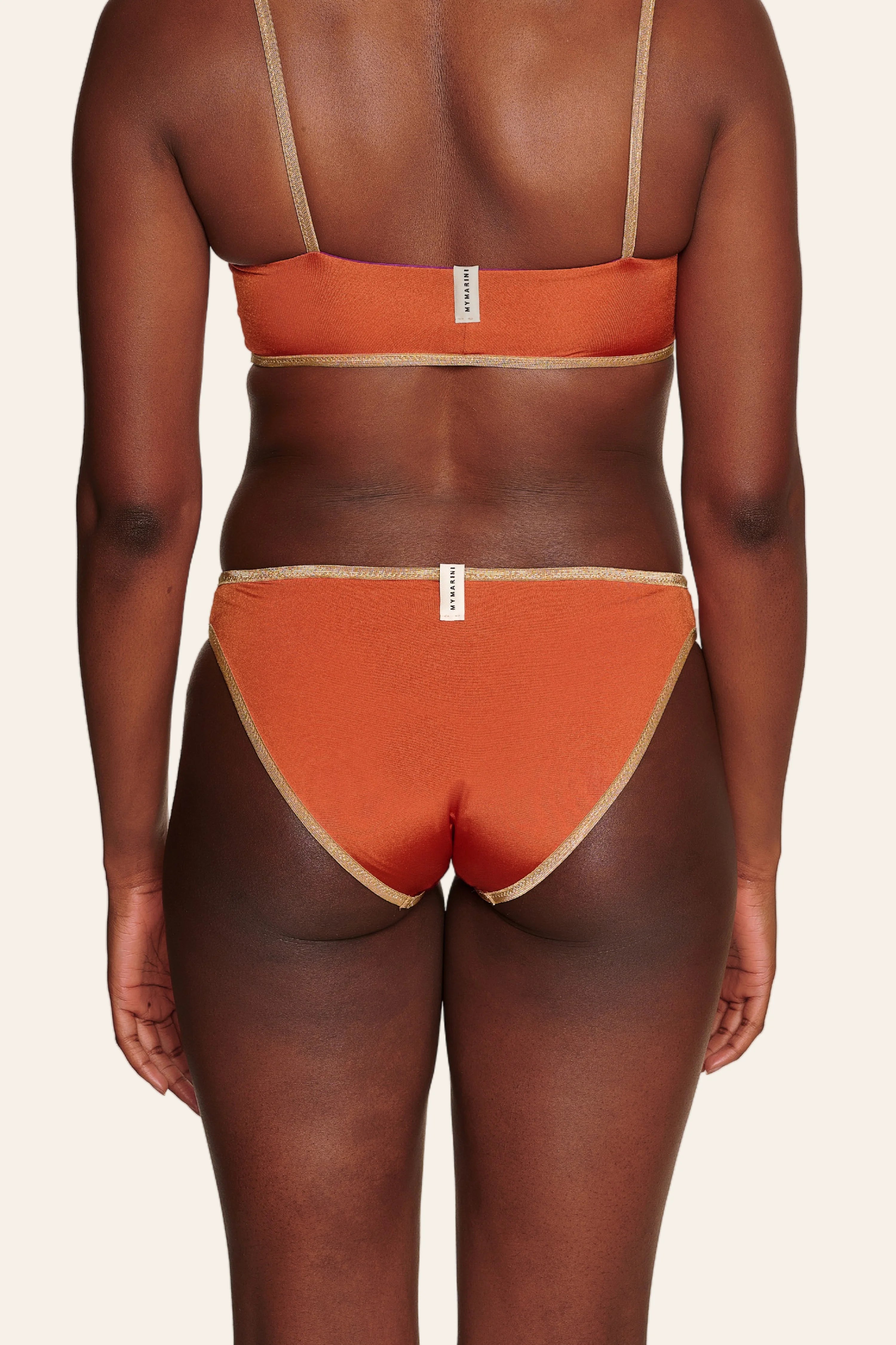 Rückansicht eines orangefarbenen MYMARINI Bikinis mit Spaghettiträgern und mittlerem Beinausschnitt.#color_papaya-cassis
