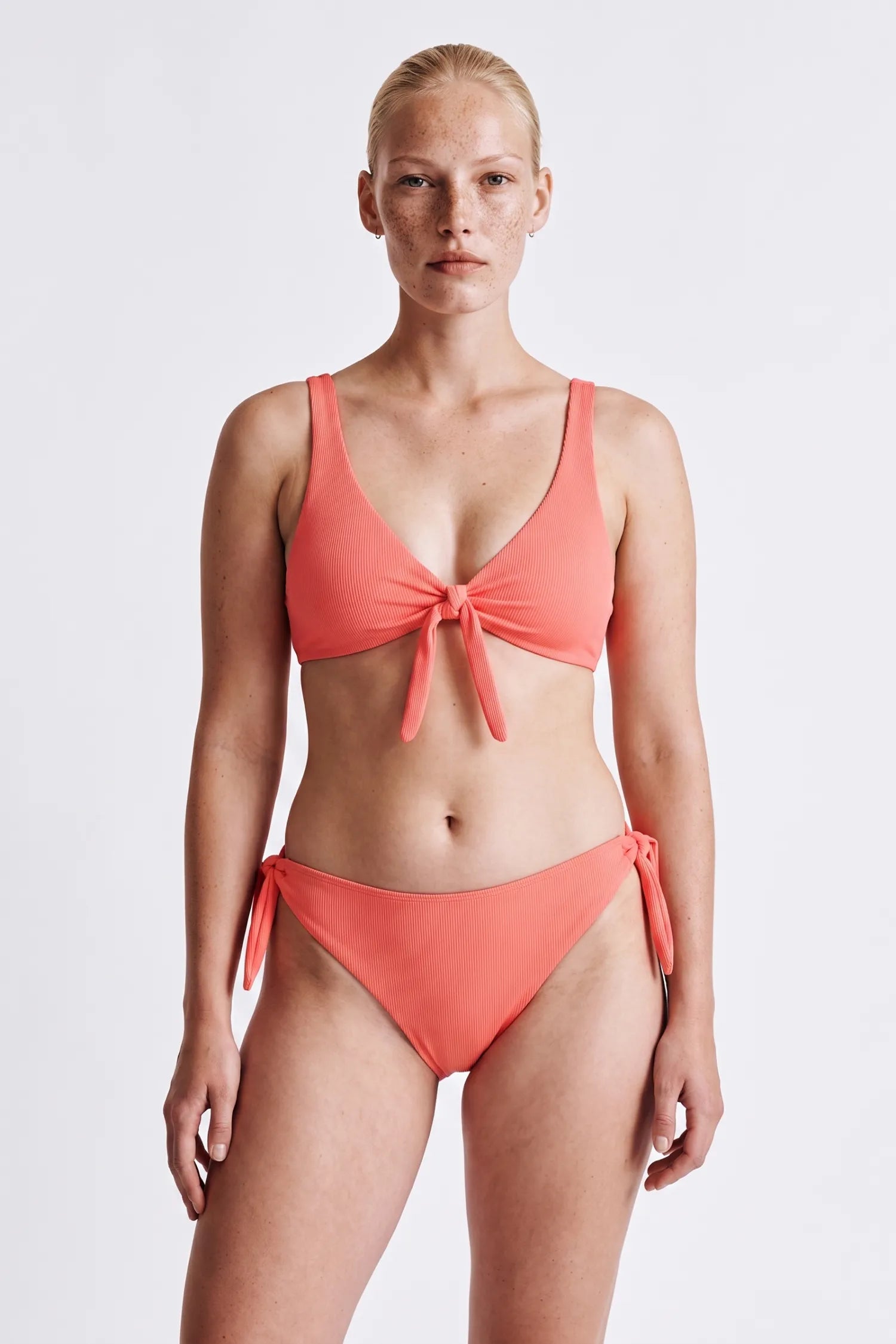 KI-generiert, Frau trägt MYMARINI BOW SET Bikini in sorbet, Top mit Schleife, tief sitzende Hose mit Seitenschleifen#color_sorbet