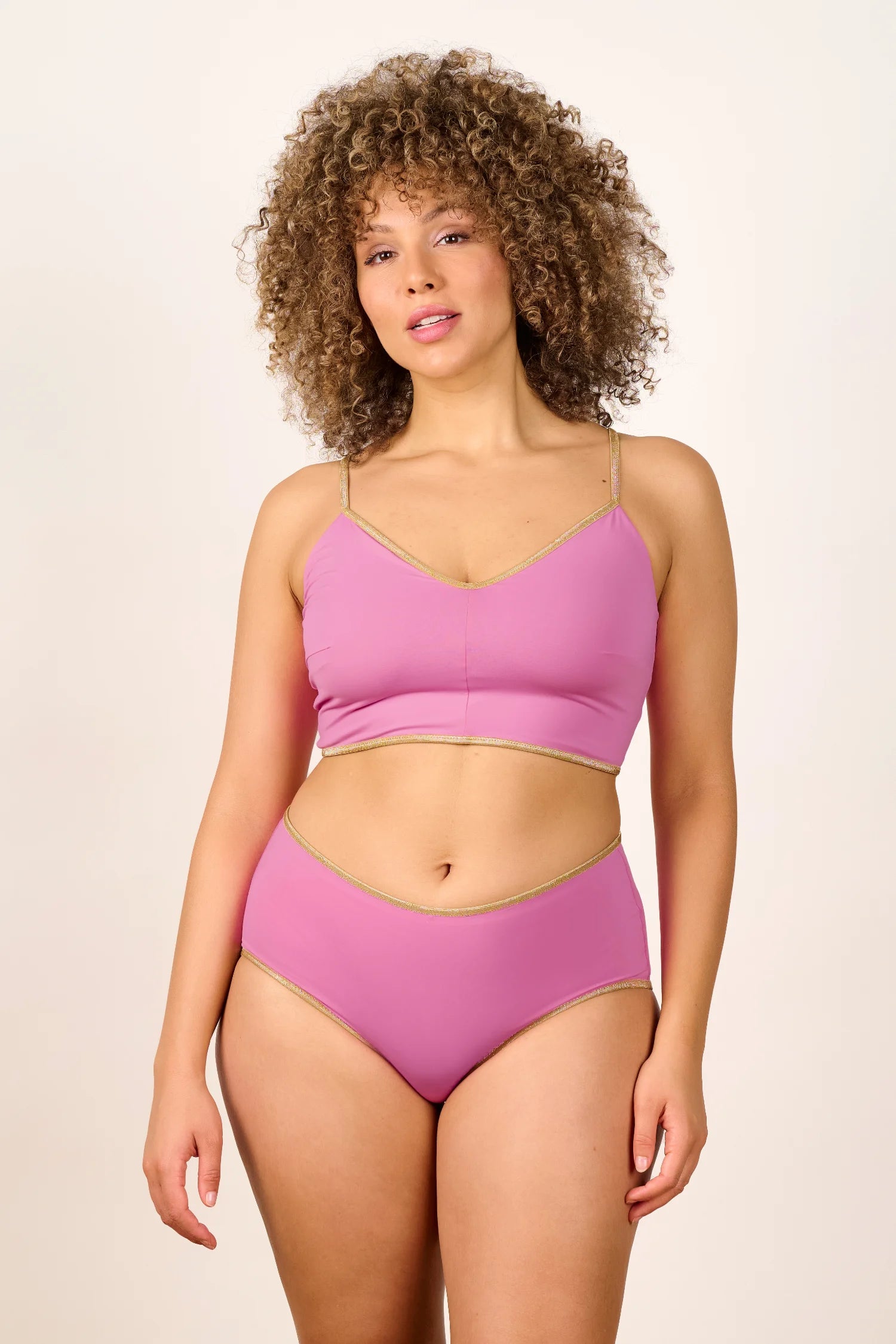 Frau trägt MYMARINI Bikini mit V-Ausschnitt und breiten Trägern in Rosa.#color_bronze-orchid