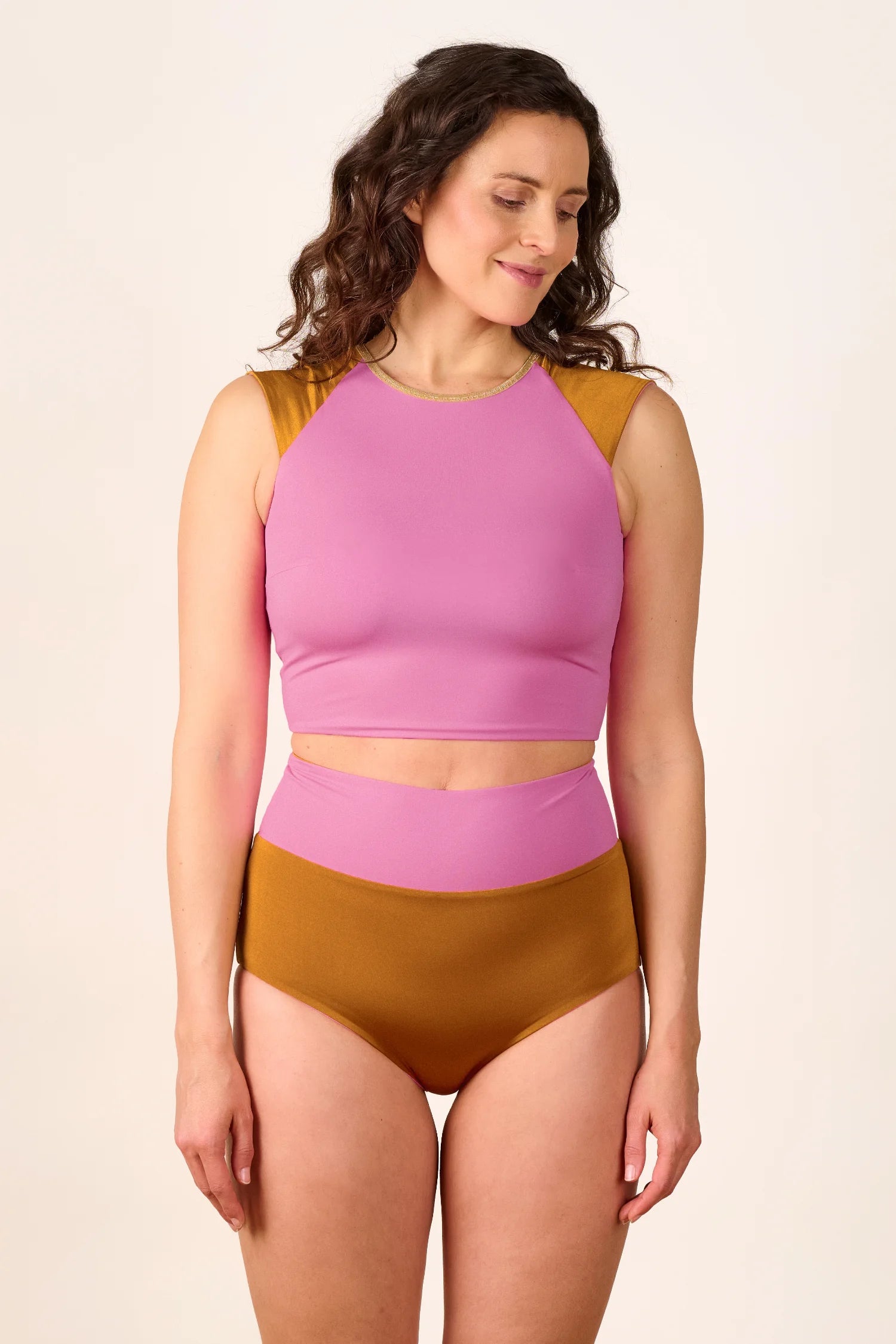 Frau trägt MYMARINI Bikini mit hochgeschlossenem Top und High-Waist-Hose in Rosa und Braun.#color_bronze-orchid