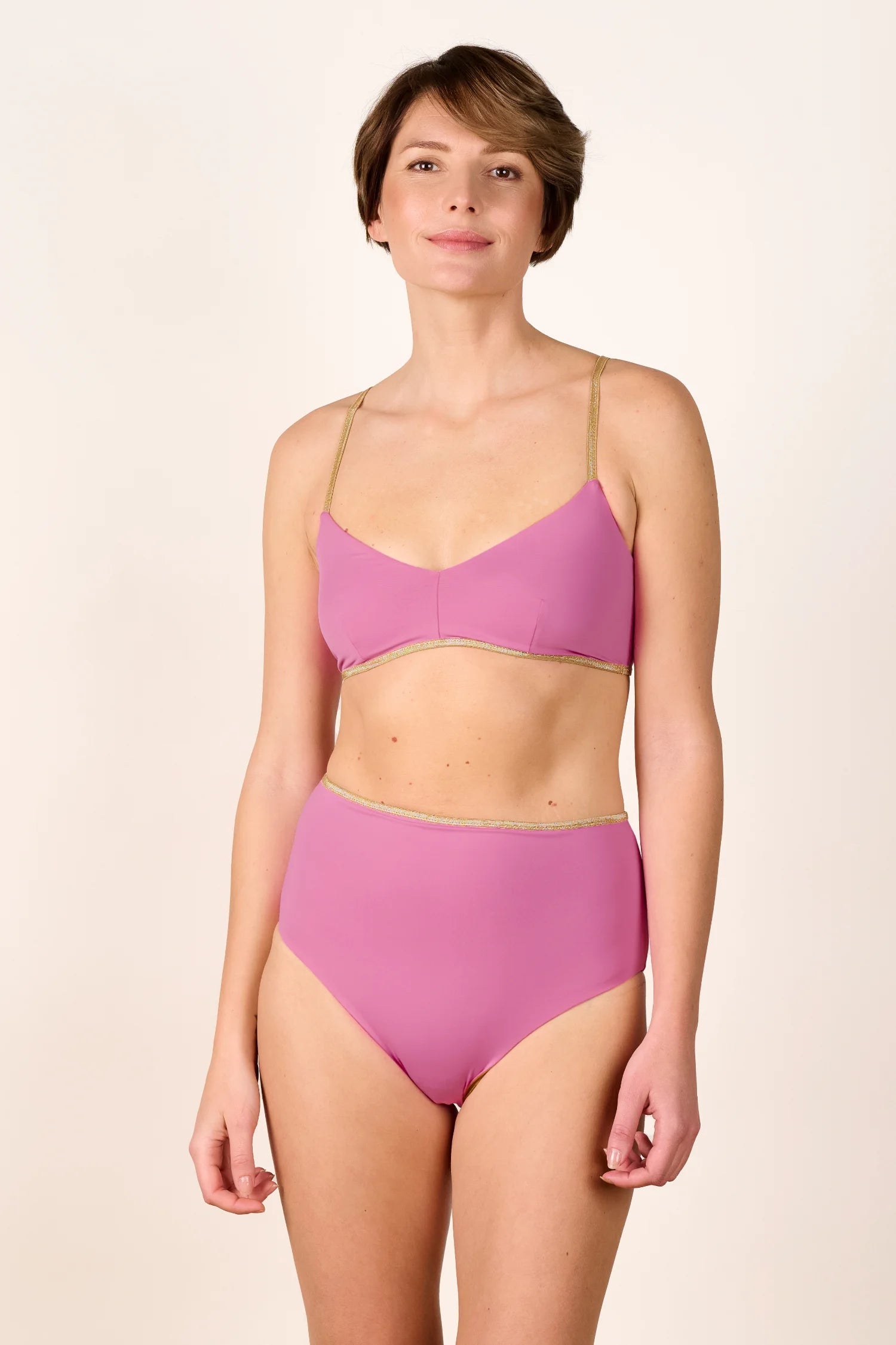 Person trägt MYMARINI Bikinitop mit Spaghettiträgern und Bikinihose mit hohem Bund in Rosa.#color_bronze-orchid