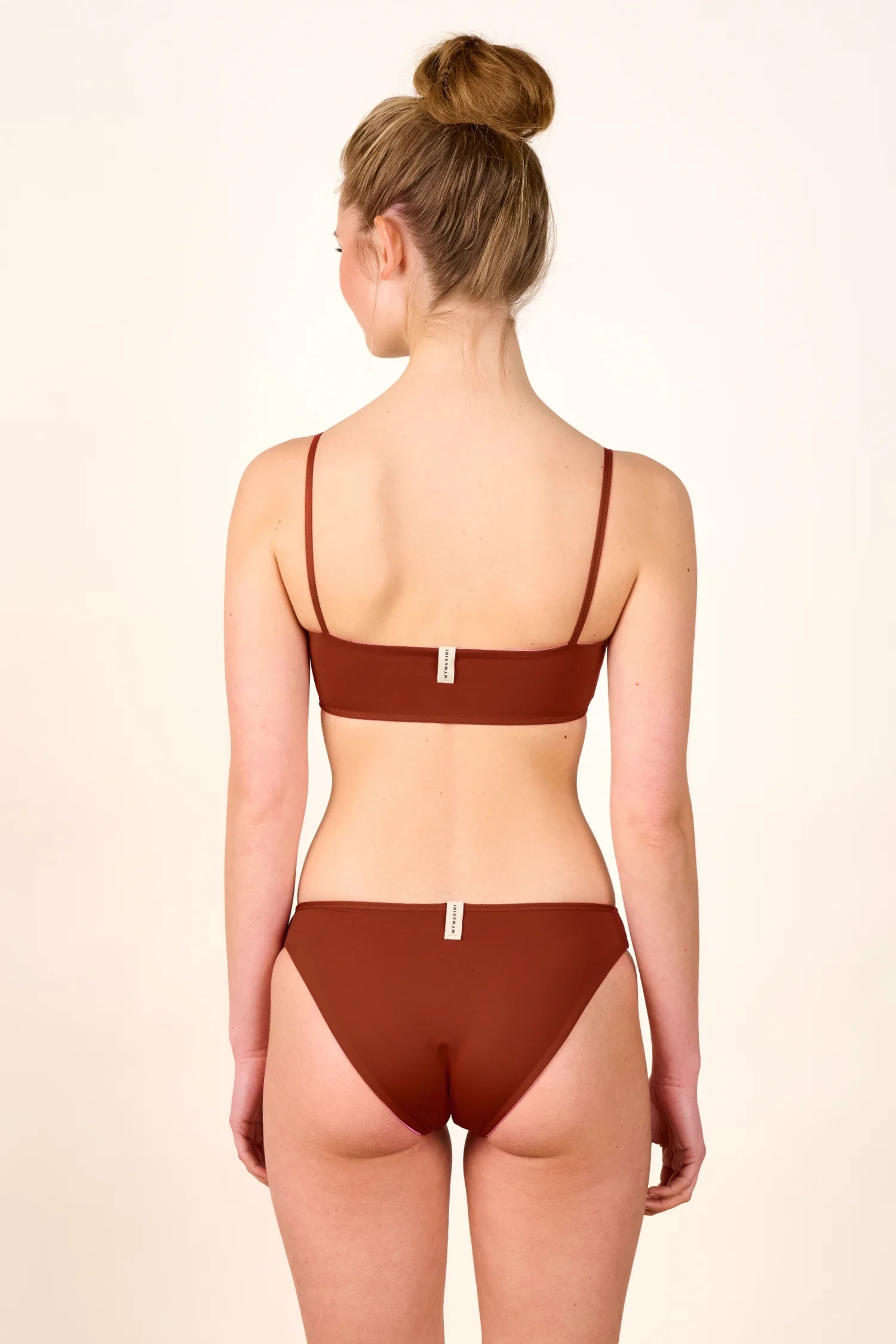 Frau in braunem MYMARINI Bikini mit Spaghettiträgern und hohem Beinausschnitt, Rückansicht.#color_sienna-orchid