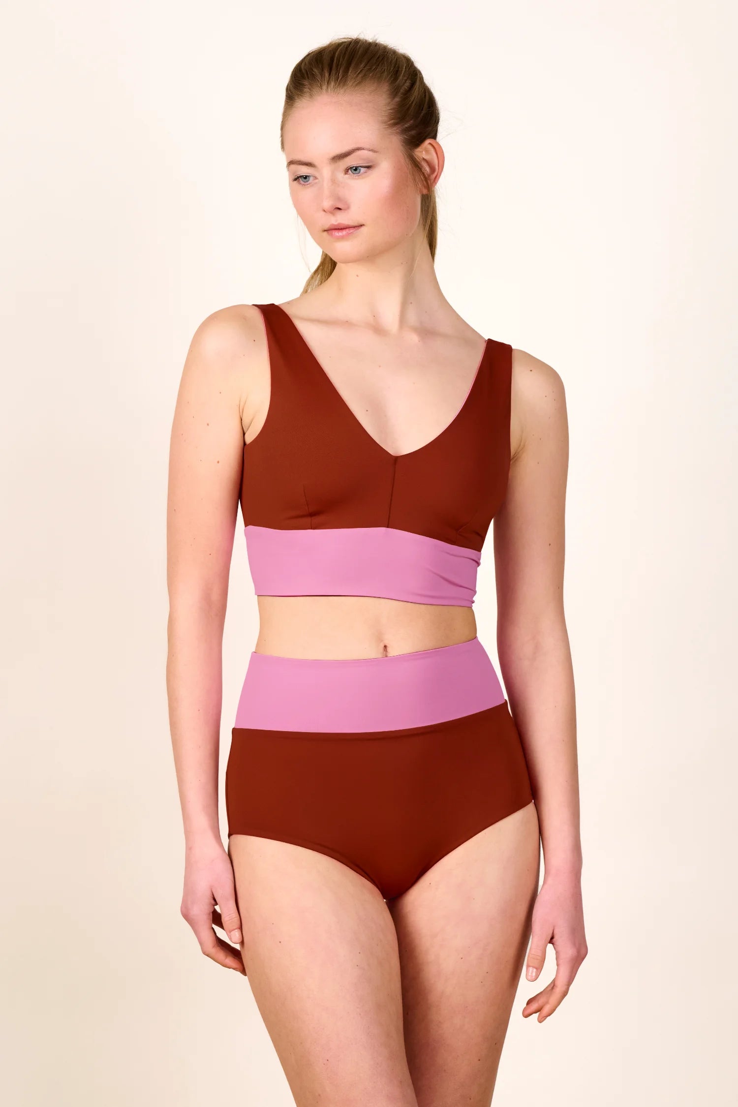 Frau trägt MYMARINI Bikini mit V-Ausschnitt und High Waist in Braun und Rosa.#color_sienna-orchid