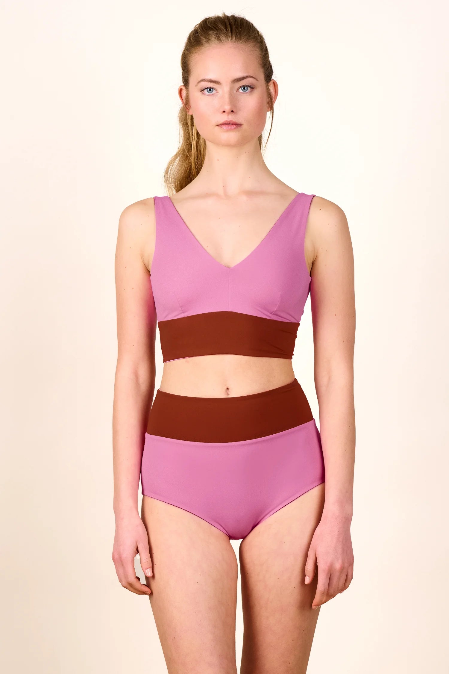 Frau trägt MYMARINI Bikini mit V-Ausschnitt und High Waist Schnitt in Rosa und Braun.#color_sienna-orchid