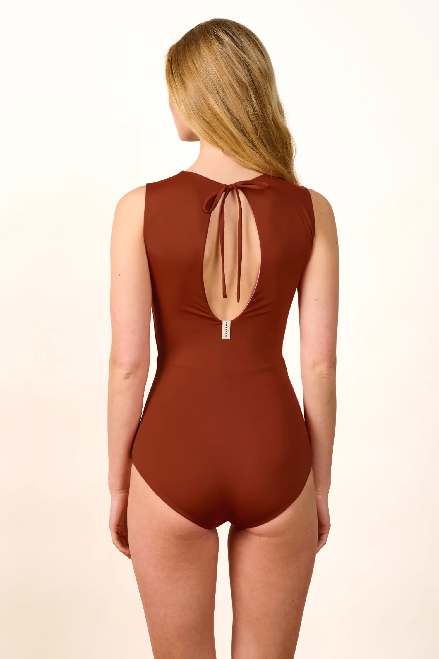 Rückansicht eines braunen MYMARINI Badeanzugs mit tiefem Rückenausschnitt und Schleife.#color_sienna-orchid