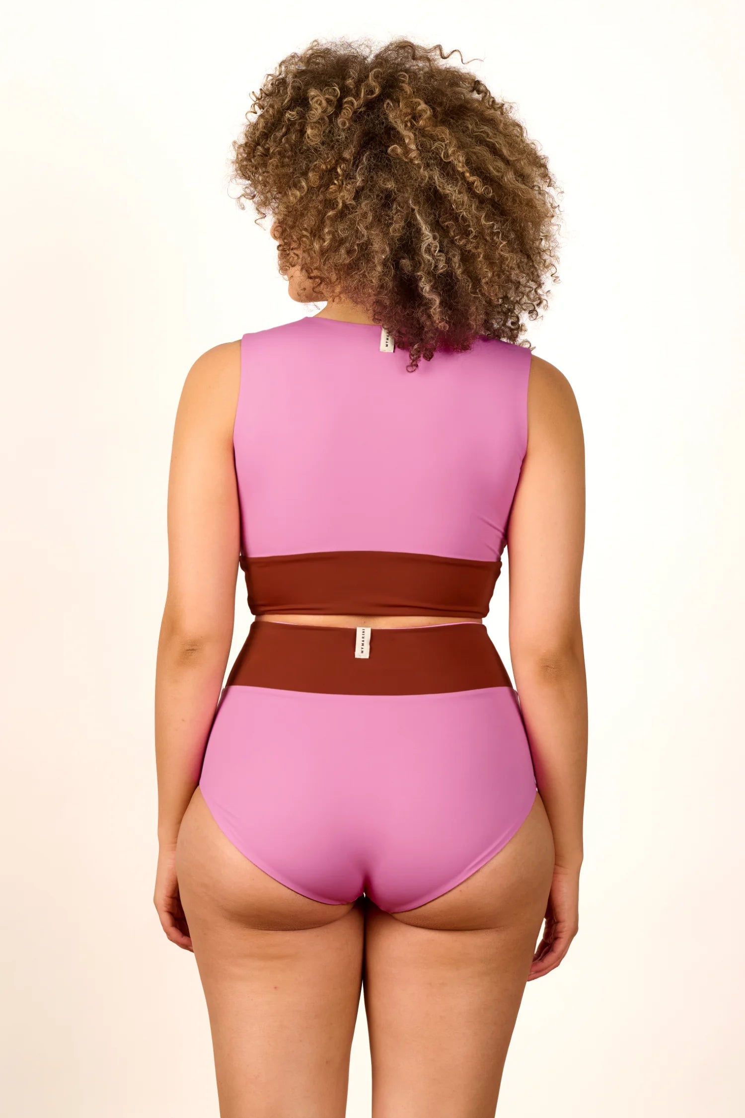 Rückansicht einer Frau in einem MYMARINI Bikini mit breiten Trägern und hohem Beinausschnitt in Rosa und Braun.#color_sienna-orchid