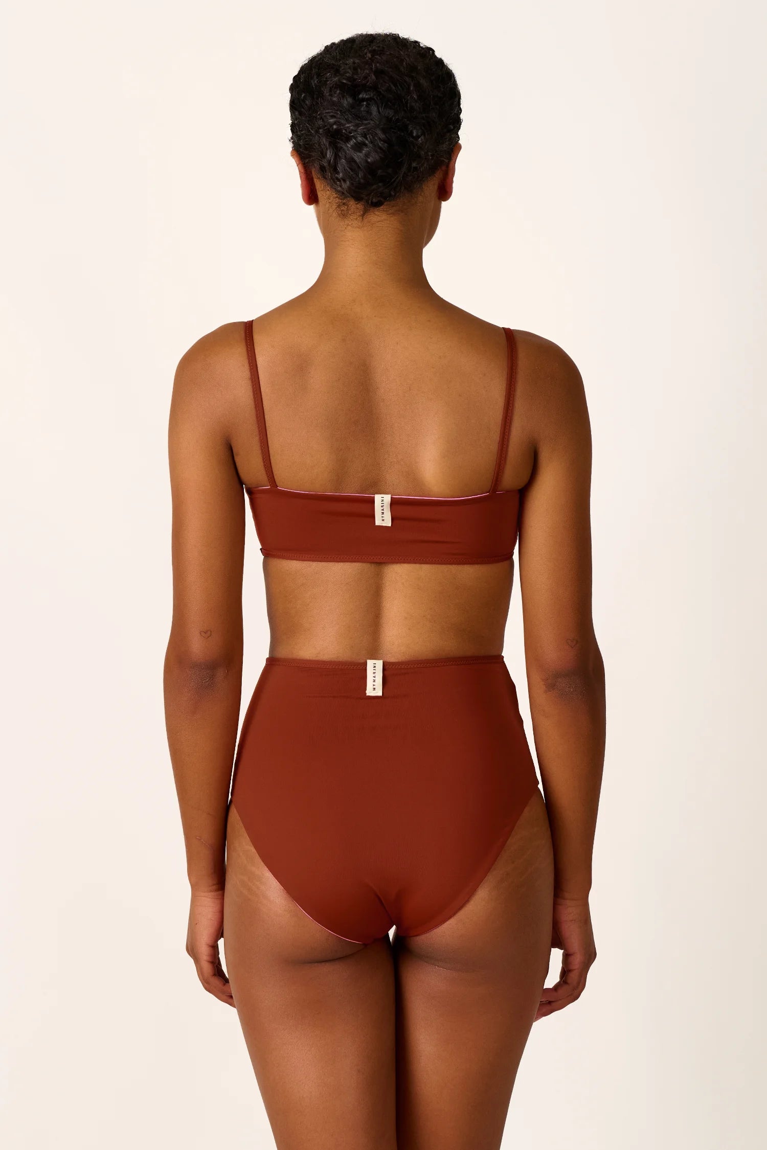 Rückansicht einer Person in MYMARINI Bikini mit Spaghettiträgern und High-Waist-Schnitt in Braun.#color_sienna-orchid
