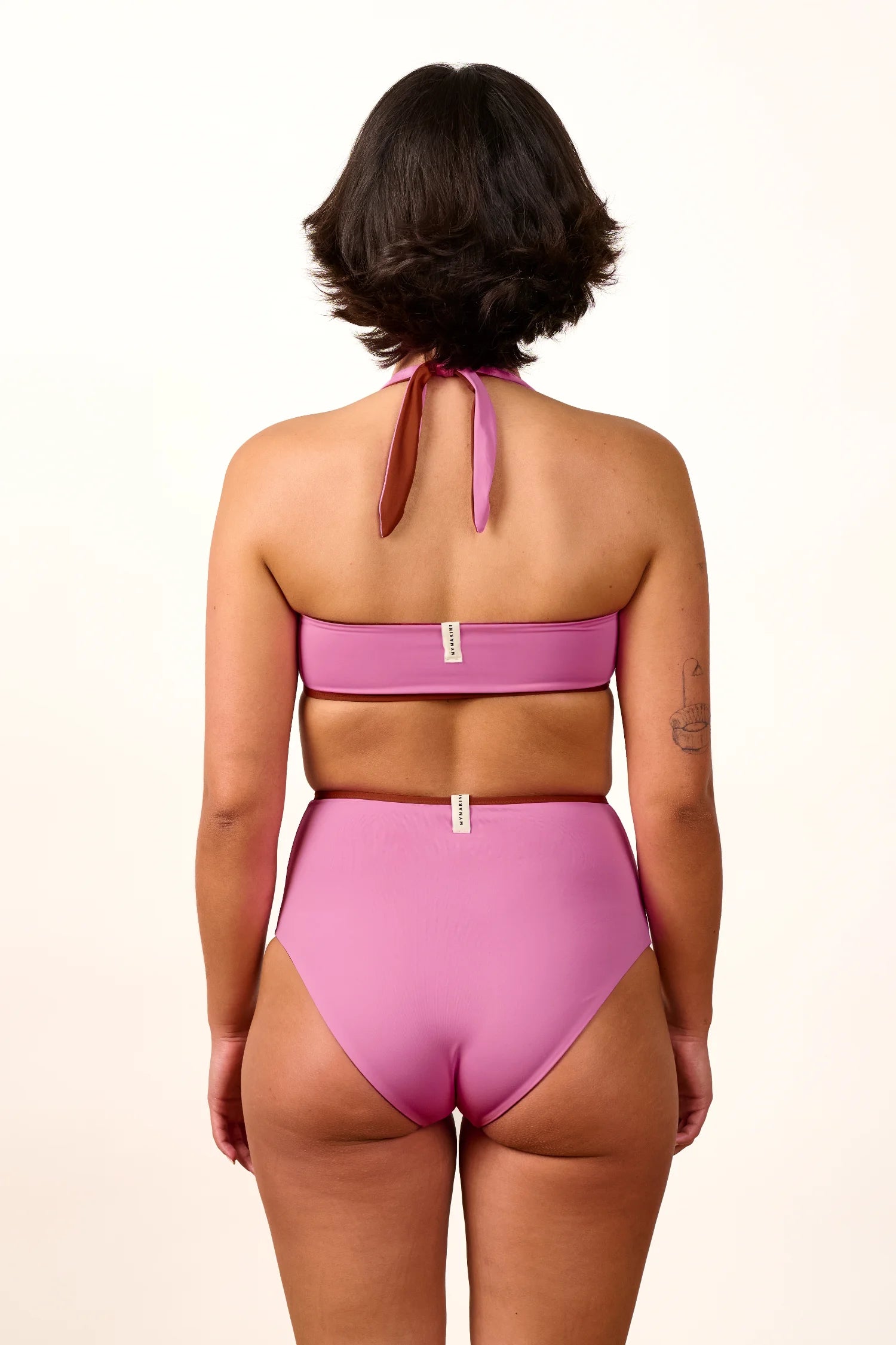 Frau von hinten in rosa MYMARINI Bikini mit Neckholder-Top und High-Waist-Hose.#color_sienna-orchid