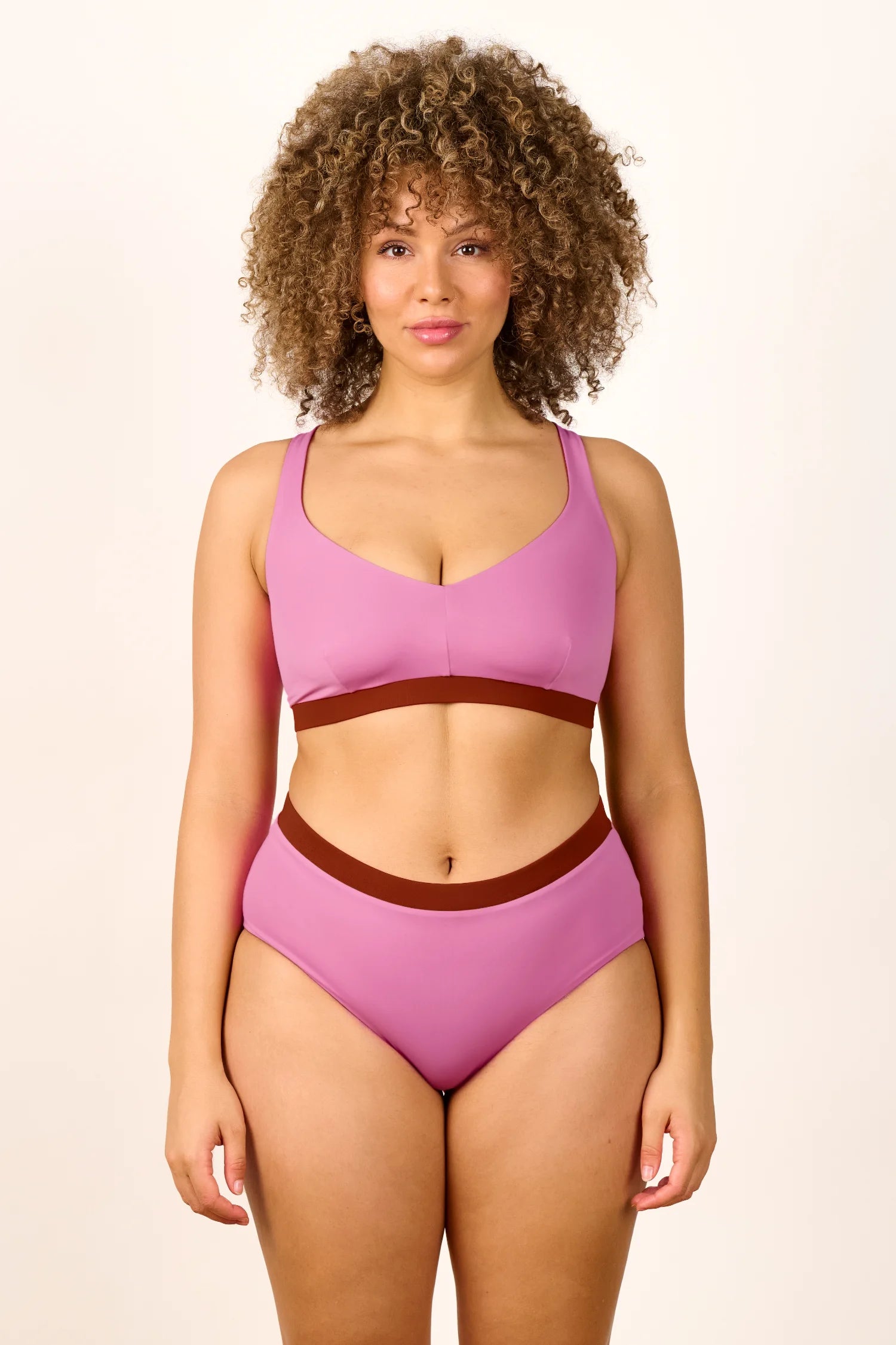 Frau trägt MYMARINI Bikini mit breiten Trägern und hoch geschnittener Bikinihose in Rosa und Braun.#color_sienna-orchid