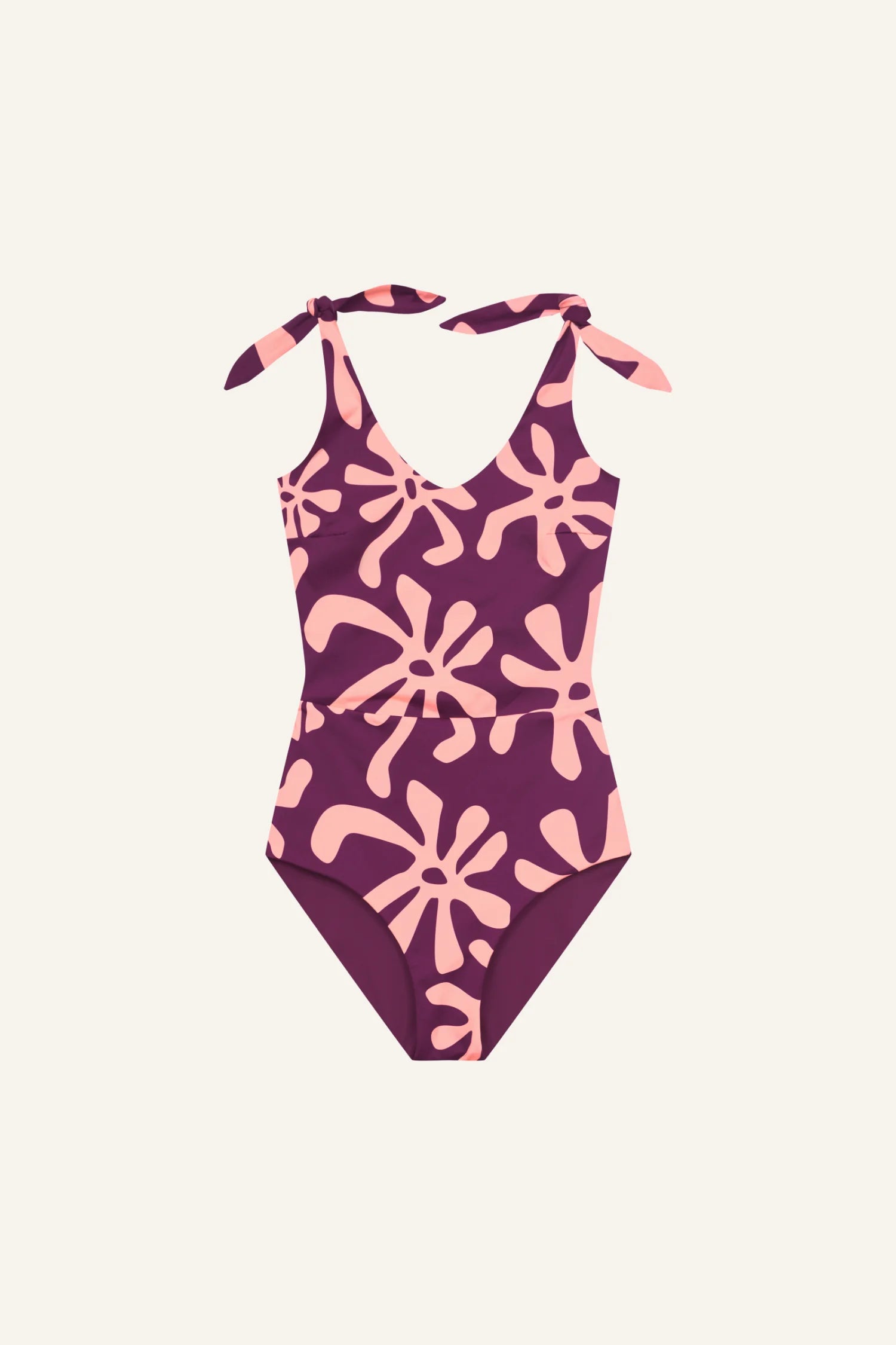 Ein MYMARINI Badeanzug mit V-Ausschnitt und breiten Trägern, lila mit rosa Muster auf hellem Hintergrund.#color_berry-print