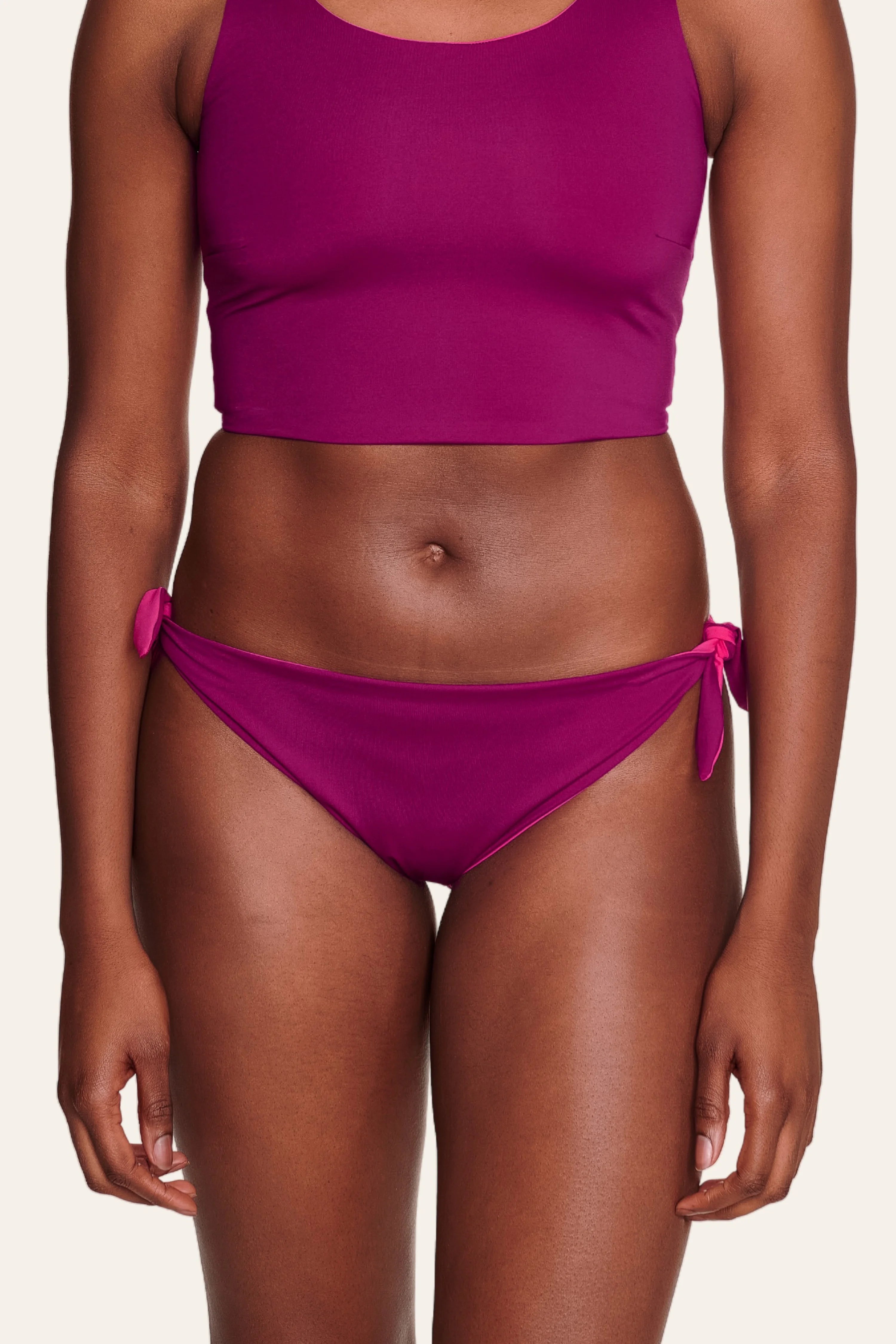 Frau trägt MYMARINI Bikinitop mit breiten Trägern und Bikinihose mit seitlichen Schleifen in kräftigem Pink.#color_pink-hortensia