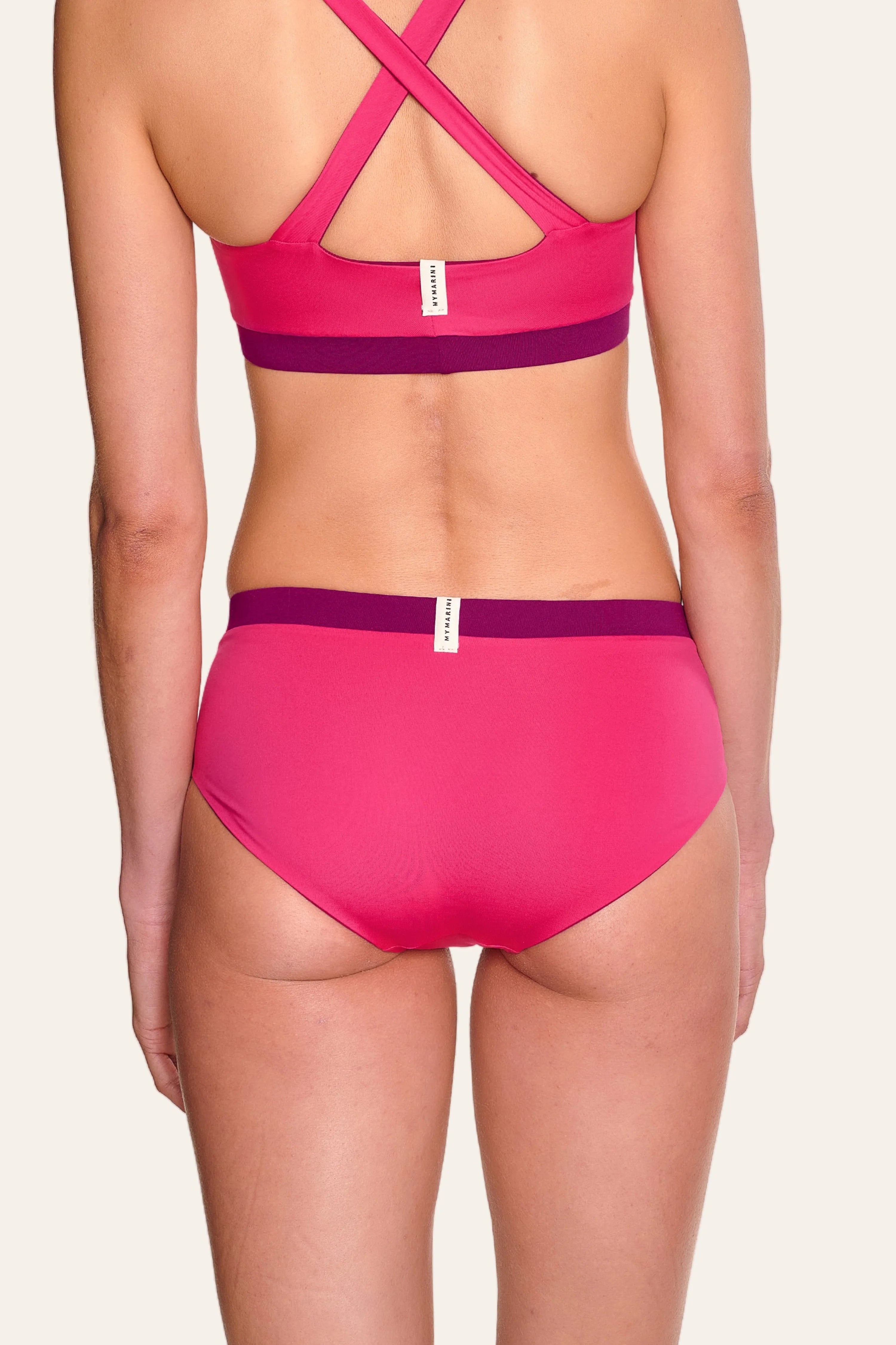 Rückansicht einer Person in einem pinken MYMARINI Bikini mit breiten Trägern und hohem Beinausschnitt.#color_pink-hortensia