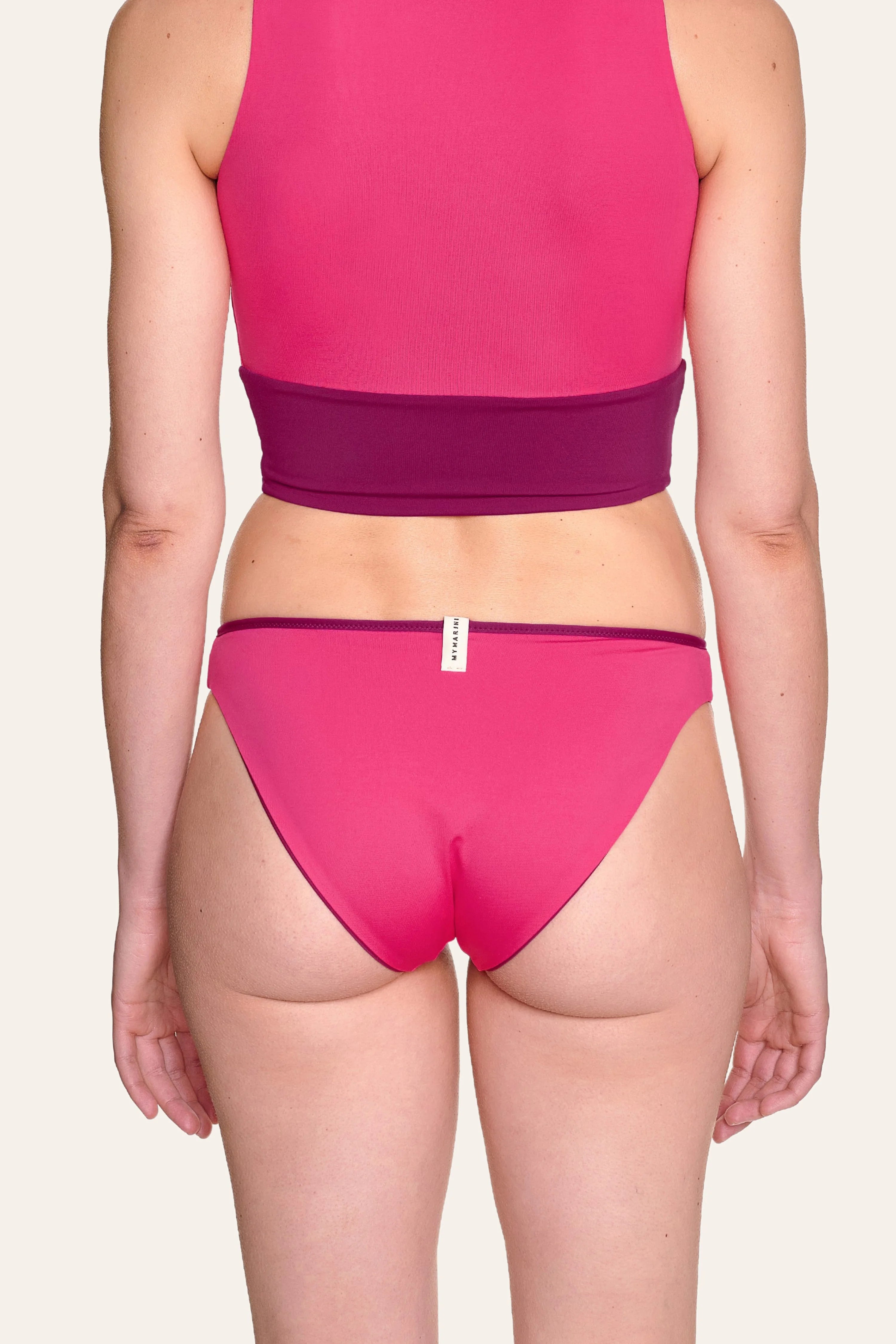 Rückansicht einer Person in pinkem MYMARINI-Bikinitop mit breiten Trägern und passender Bikinihose.#color_pink-hortensia