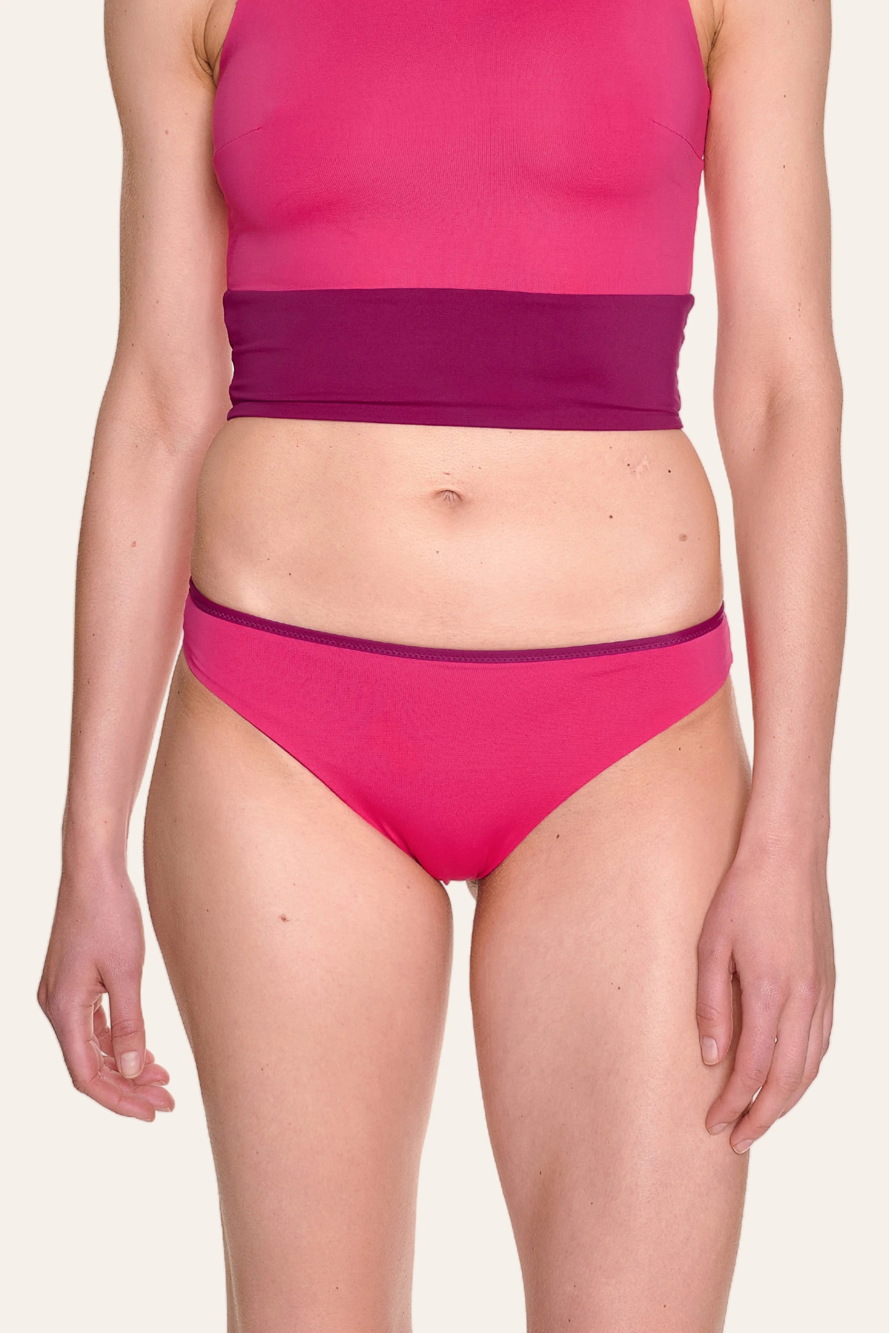 Frau trägt MYMARINI Bikinihose mit hohem Beinausschnitt in Pink und Lila.#color_pink-hortensia
