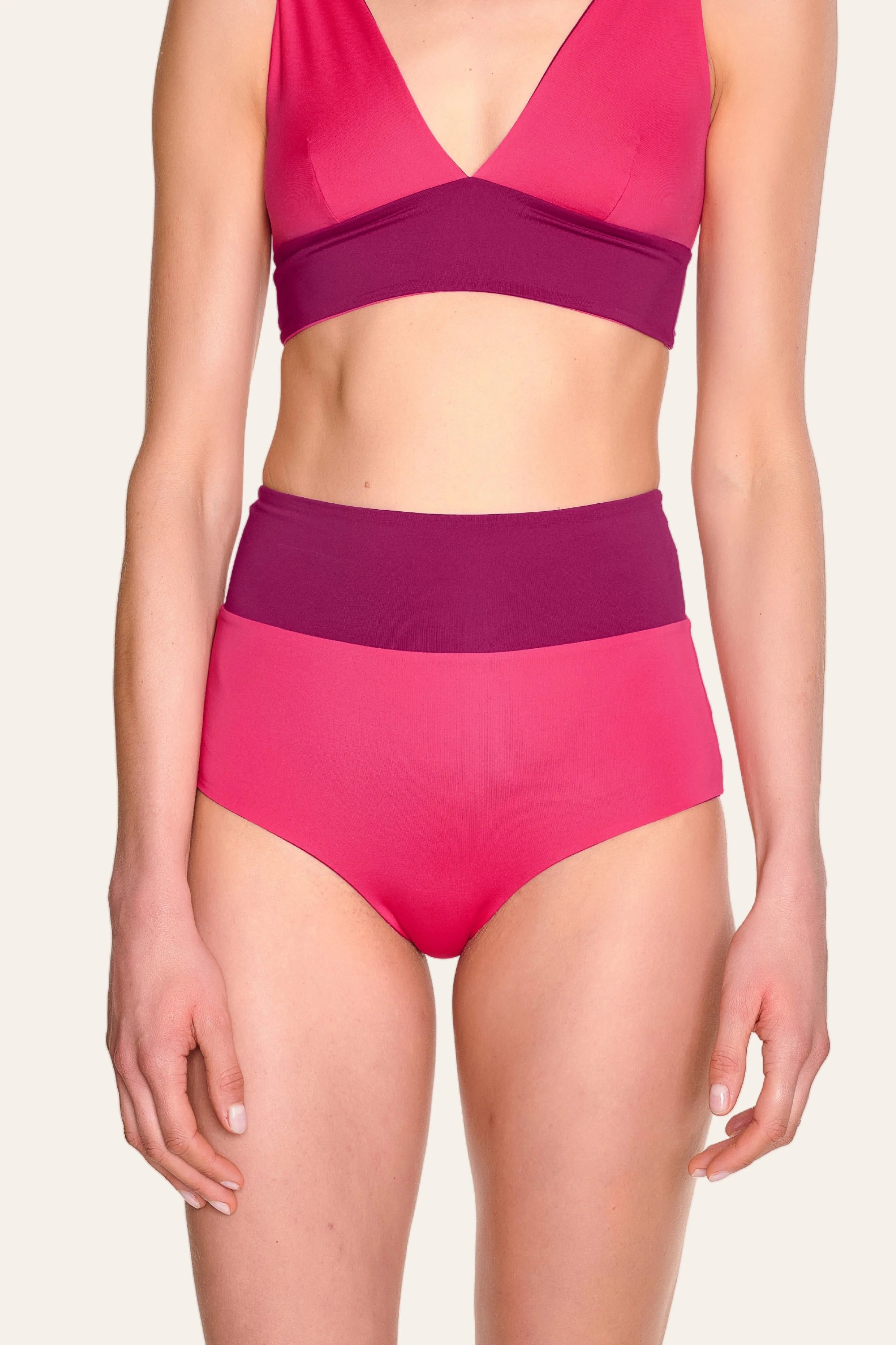 Person trägt MYMARINI Bikinitop mit V-Ausschnitt und Bikinihose mit hohem Bund in Pink und Lila.#color_pink-hortensia